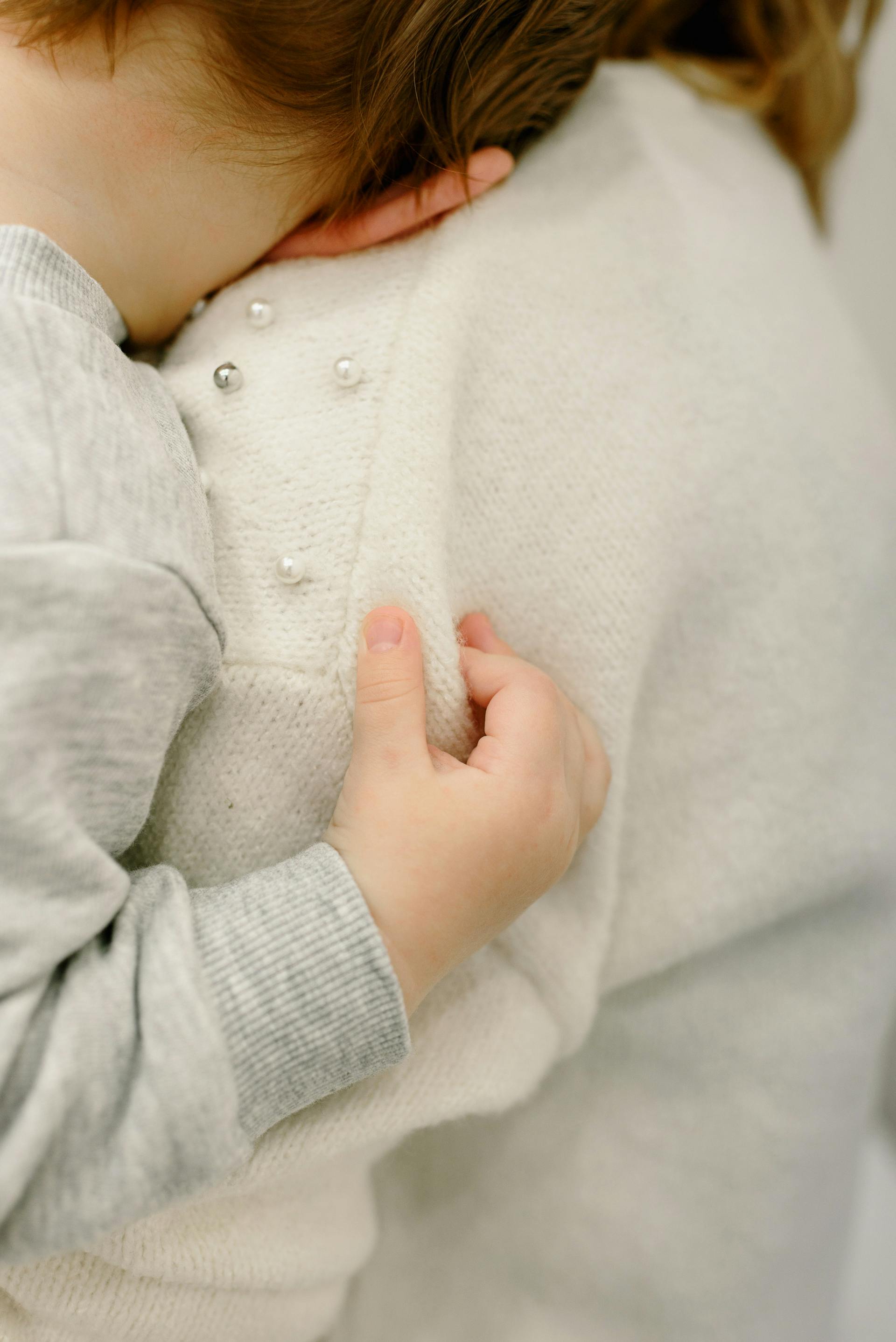 Un niño pequeño apoyado en el hombro de su madre | Fuente: Pexels