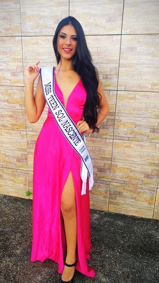 Kamila Rodrigues Cardoso posando con un vestido fucsia y una banda durante su etapa de reina de belleza | Fuente: Facebook/El Heraldo de México