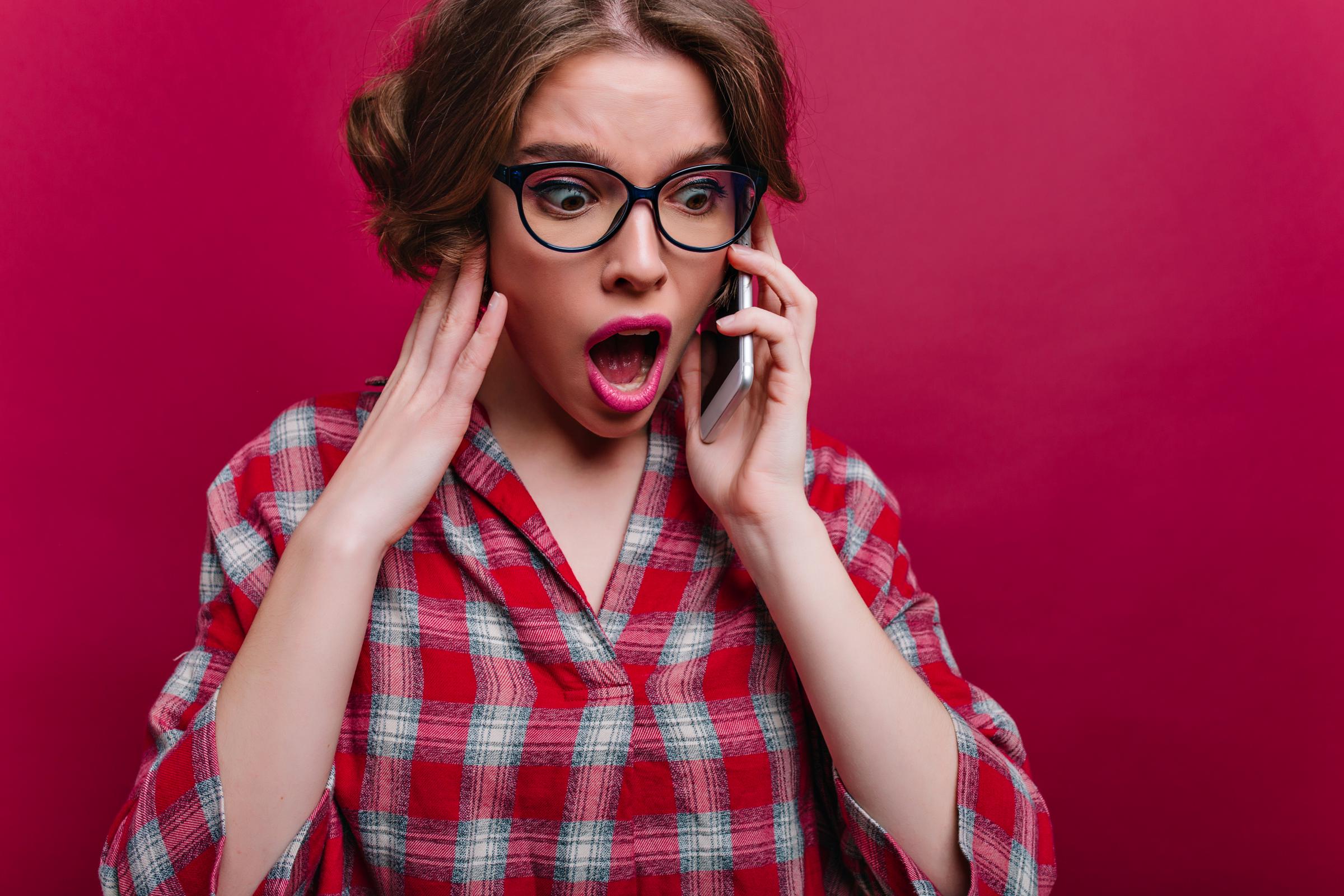 Una mujer conmocionada en una llamada | Fuente: Freepik