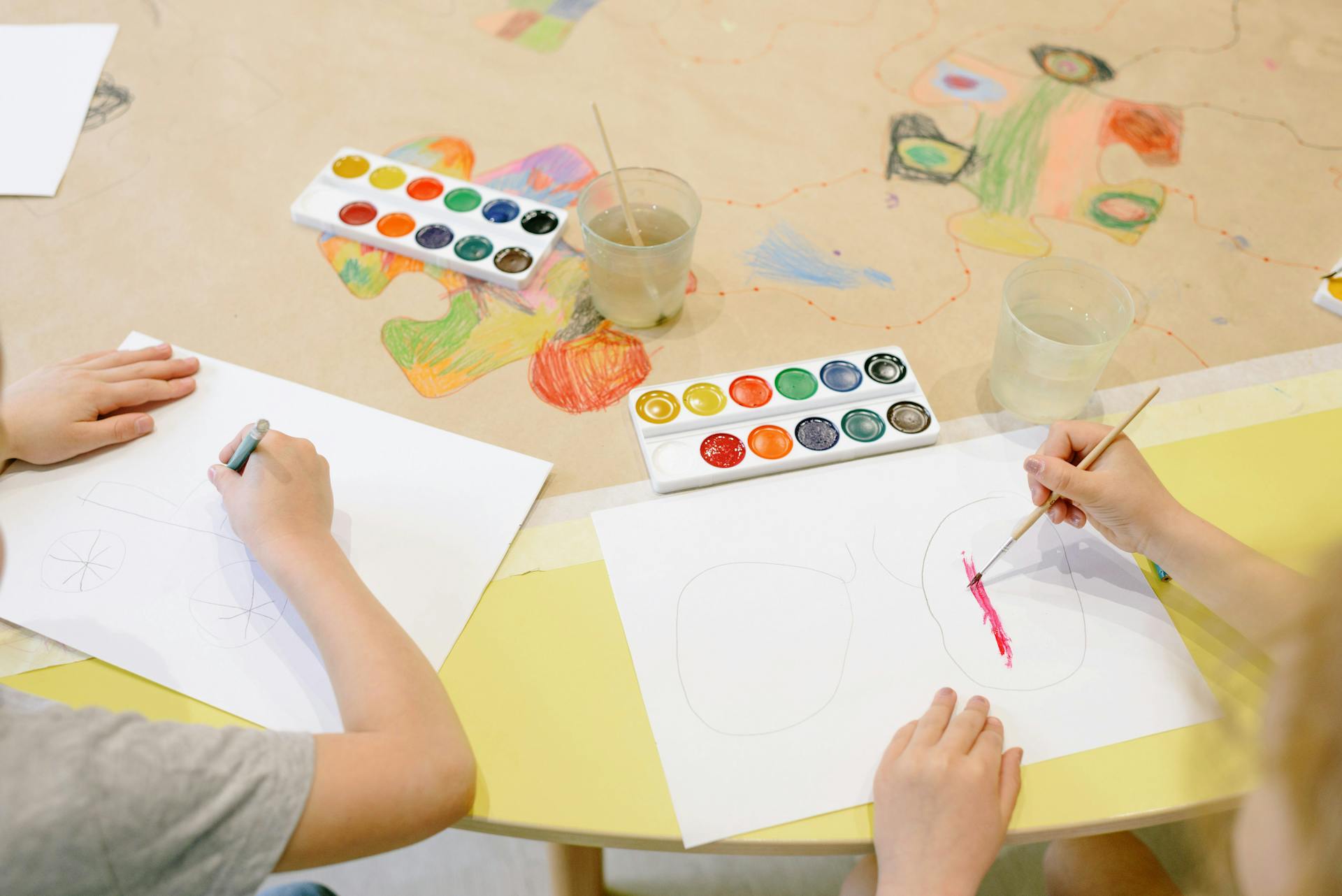 Dos niños dibujando con material artístico | Fuente: Pexels