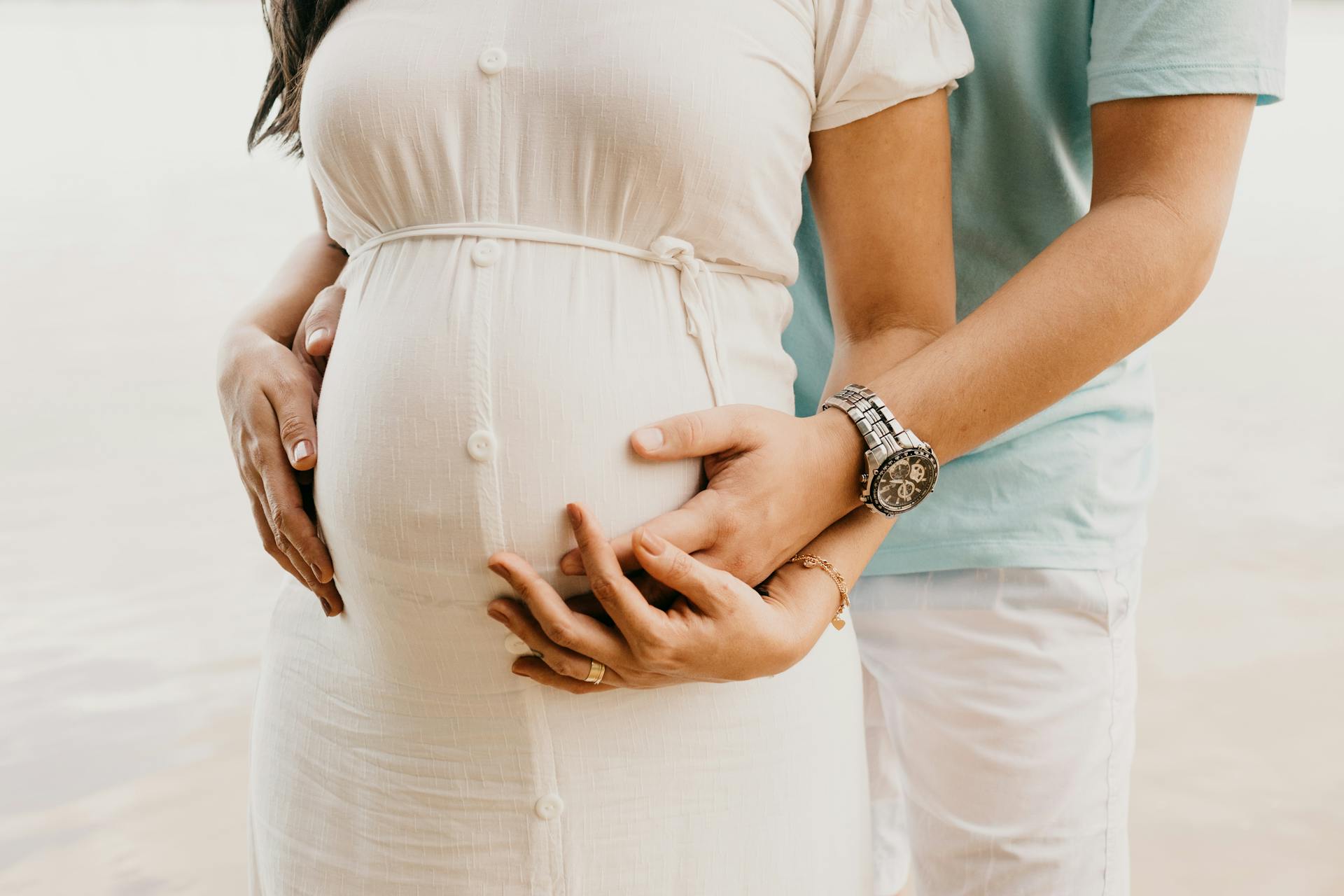 Un hombre abrazando a su pareja embarazada | Fuente: Pexels