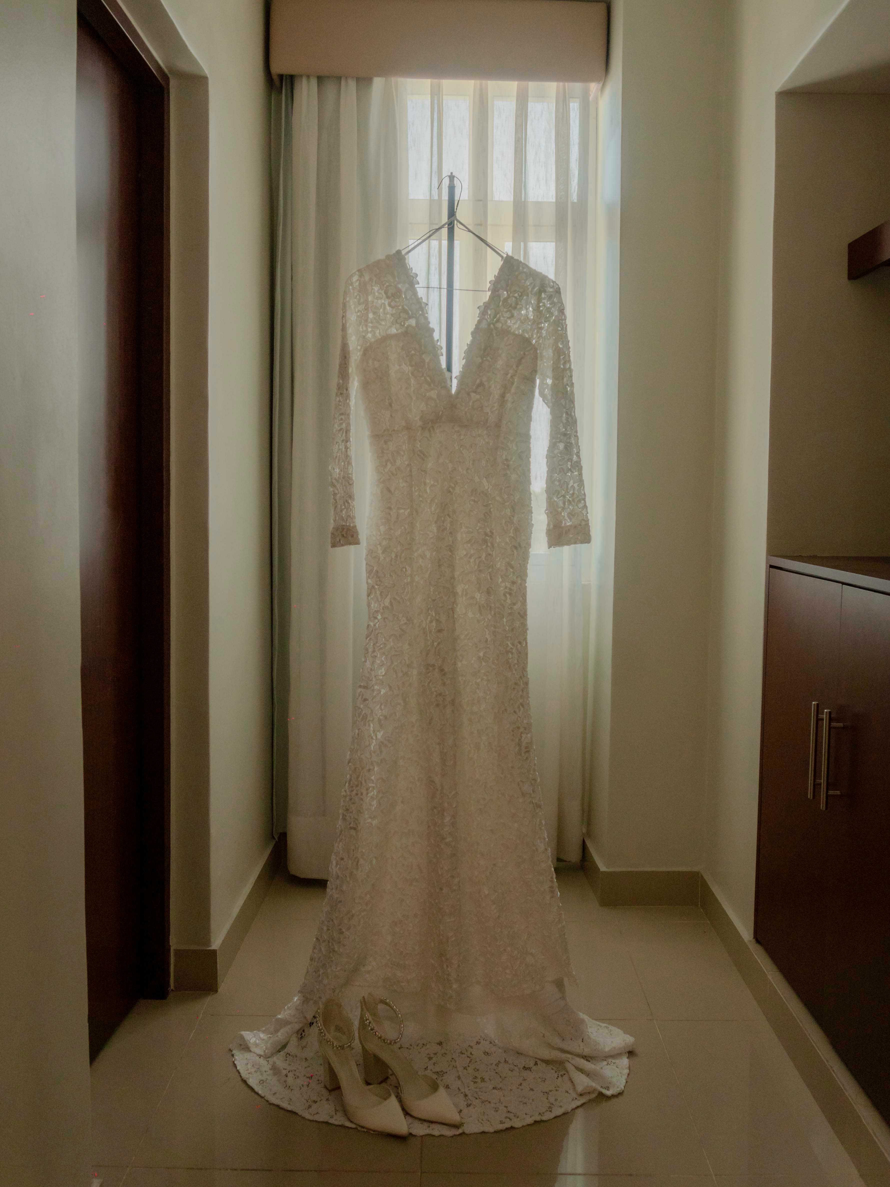 Vestido de novia colgado delante de una ventana | Fuente: Unsplash