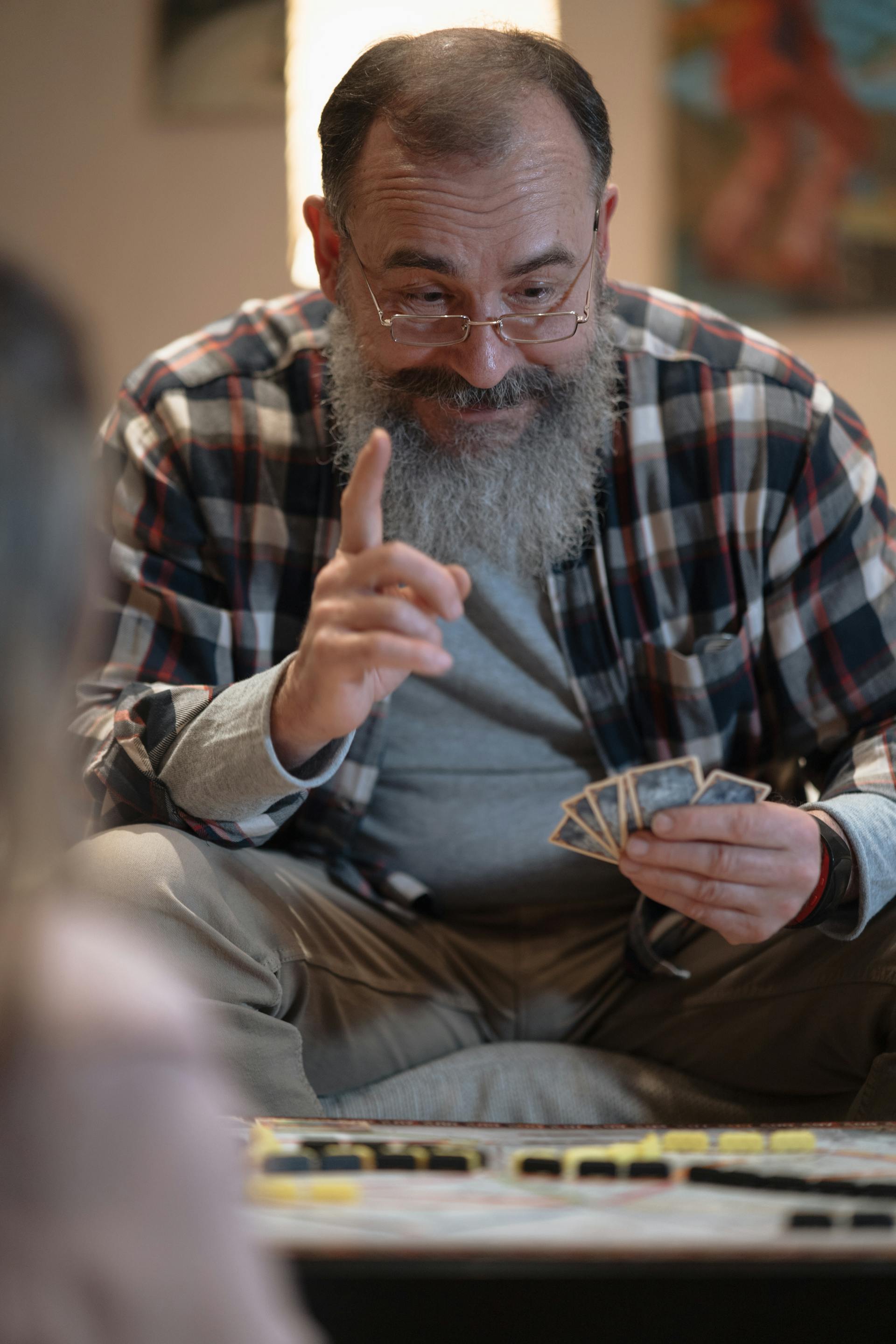 Un hombre feliz jugando a las cartas | Fuente: Pexels