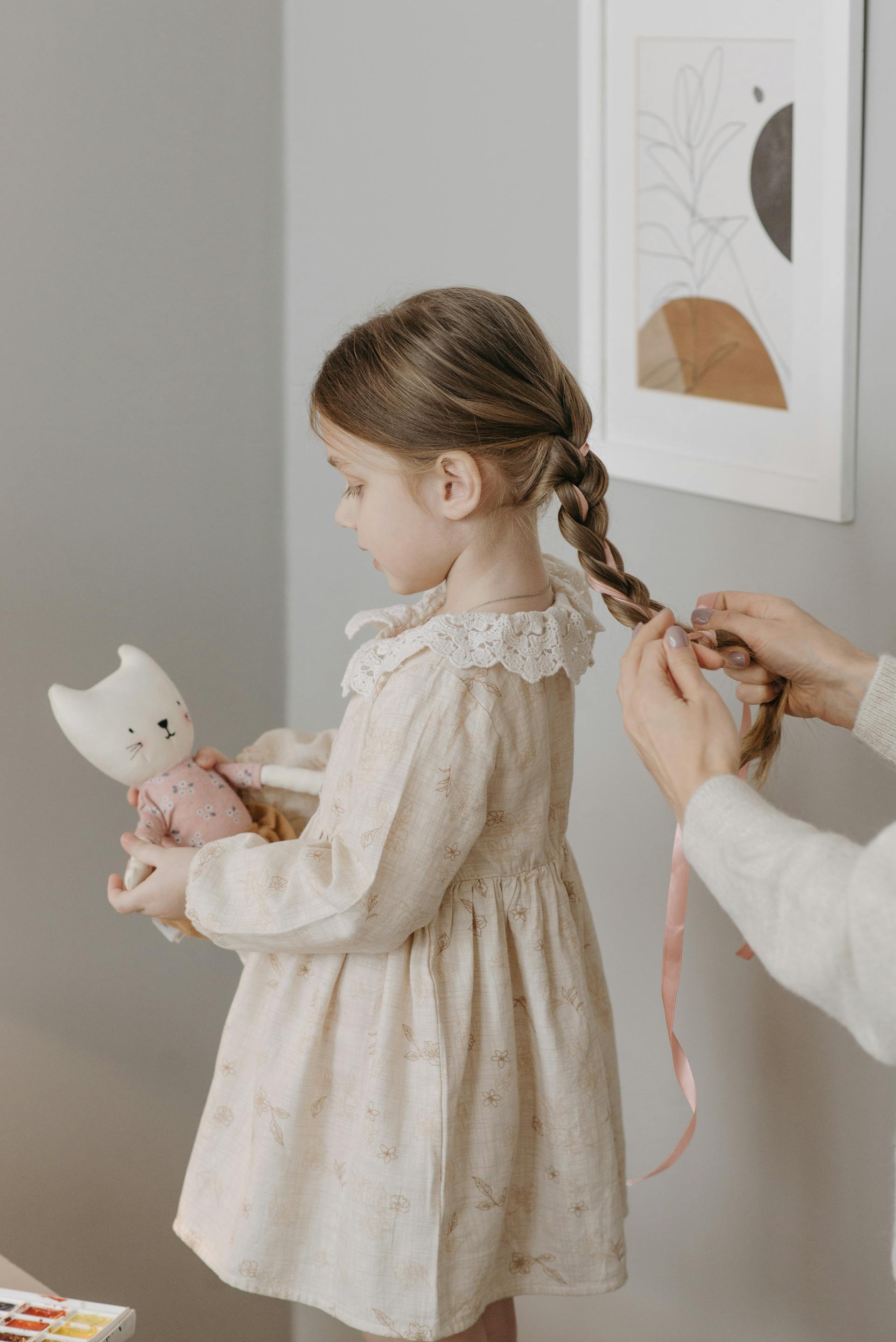 Una mujer trenzando el pelo de su hija | Fuente: Pexels