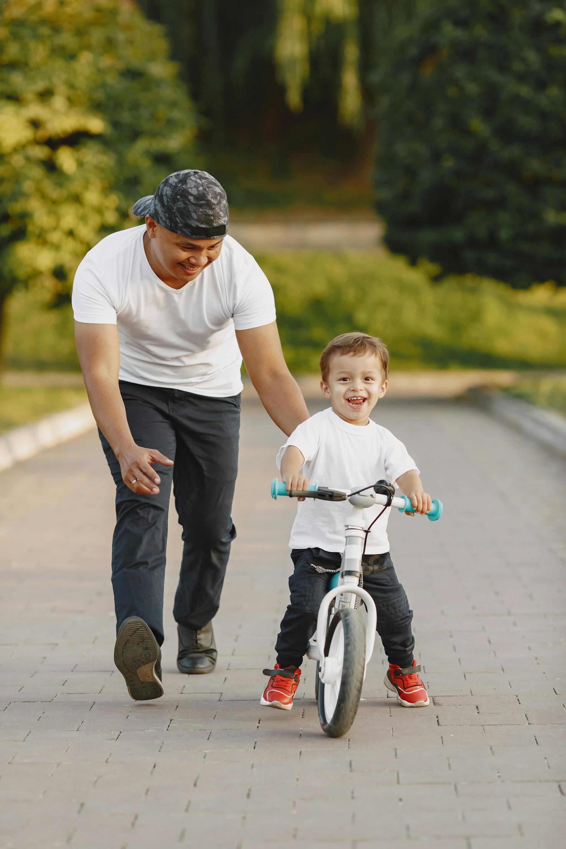 Un hombre guiando a su hijo a montar en bicicleta | Fuente: Pexels