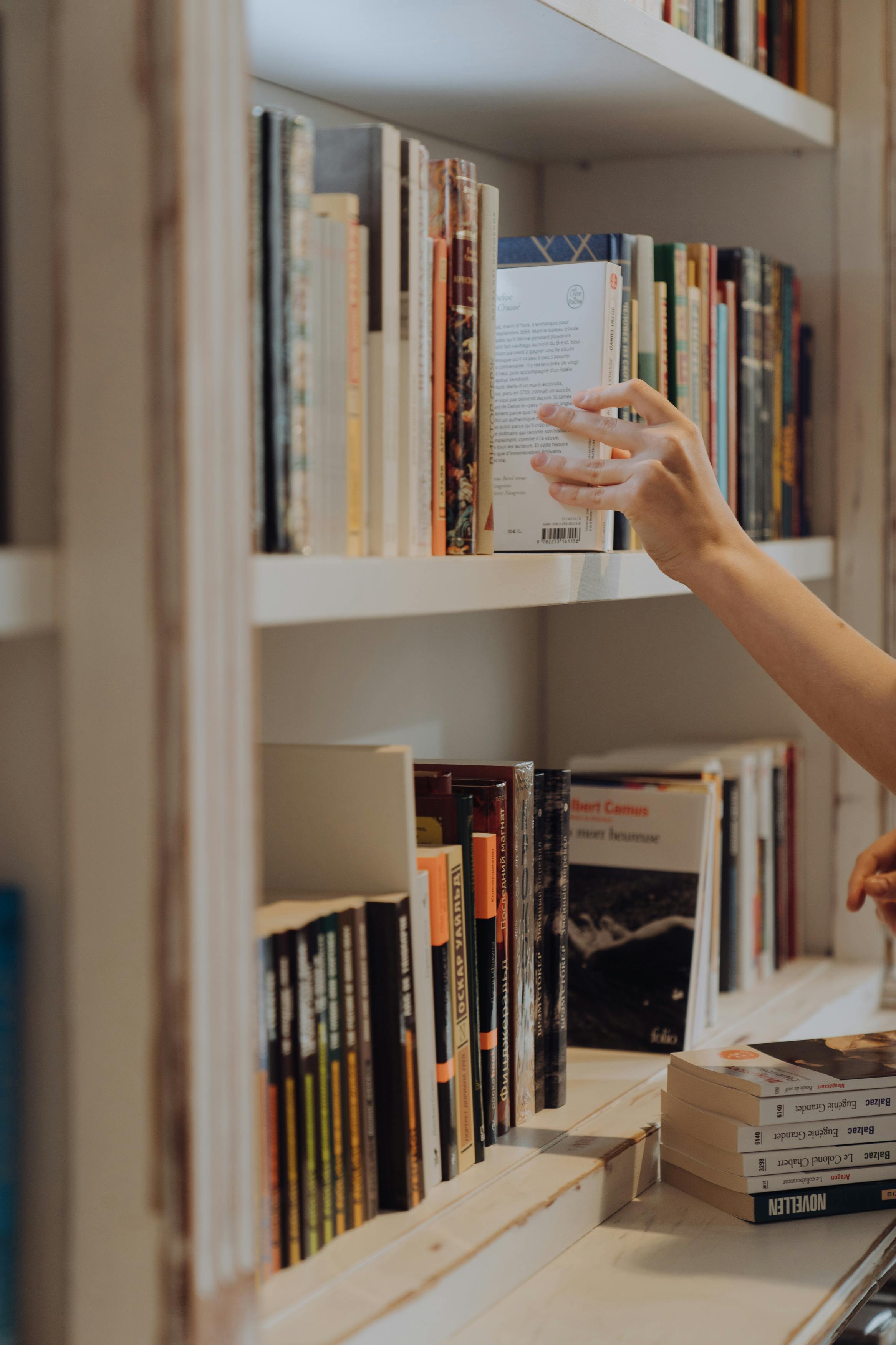 Una persona busca un libro en una biblioteca | Fuente: Pexels