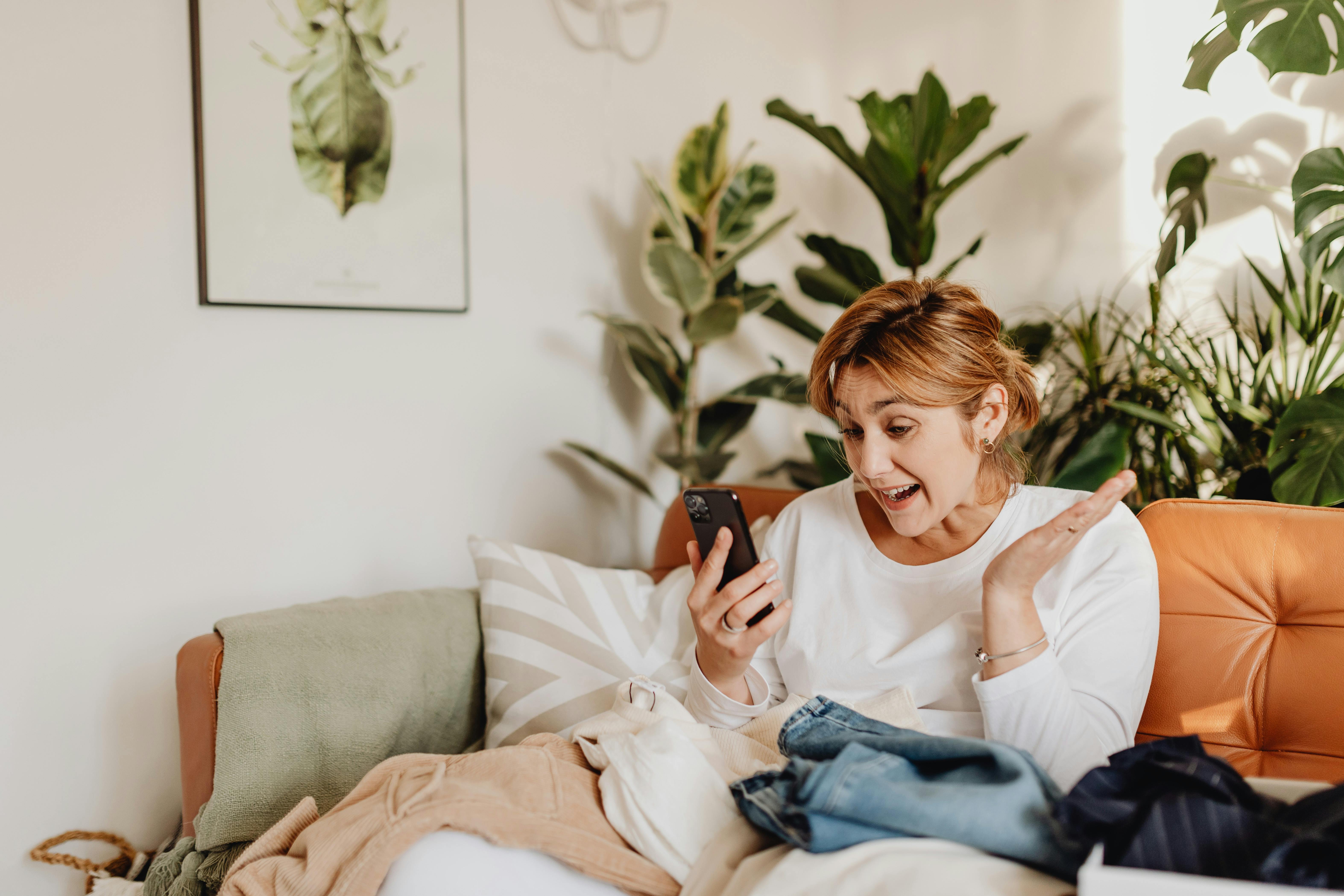 Una mujer emocionada mirando su teléfono | Fuente: Pexels