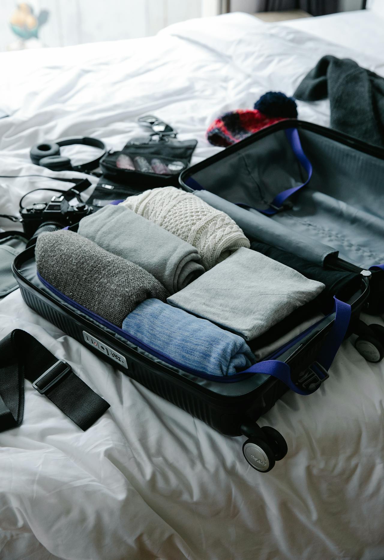 Ropa y accesorios de viaje en una maleta | Fuente: Pexels