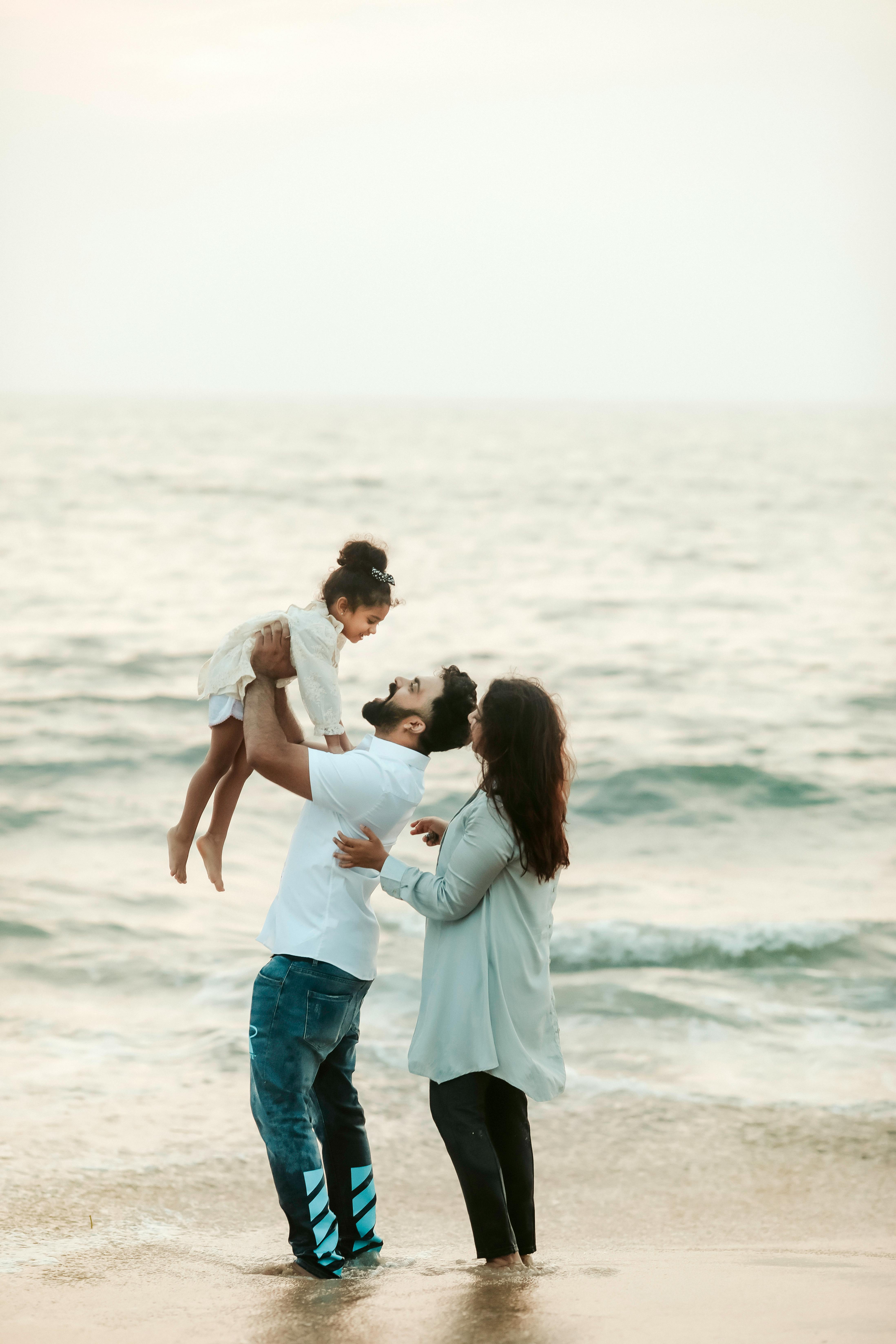 Una pareja y su hija en la playa | Fuente: Pexels
