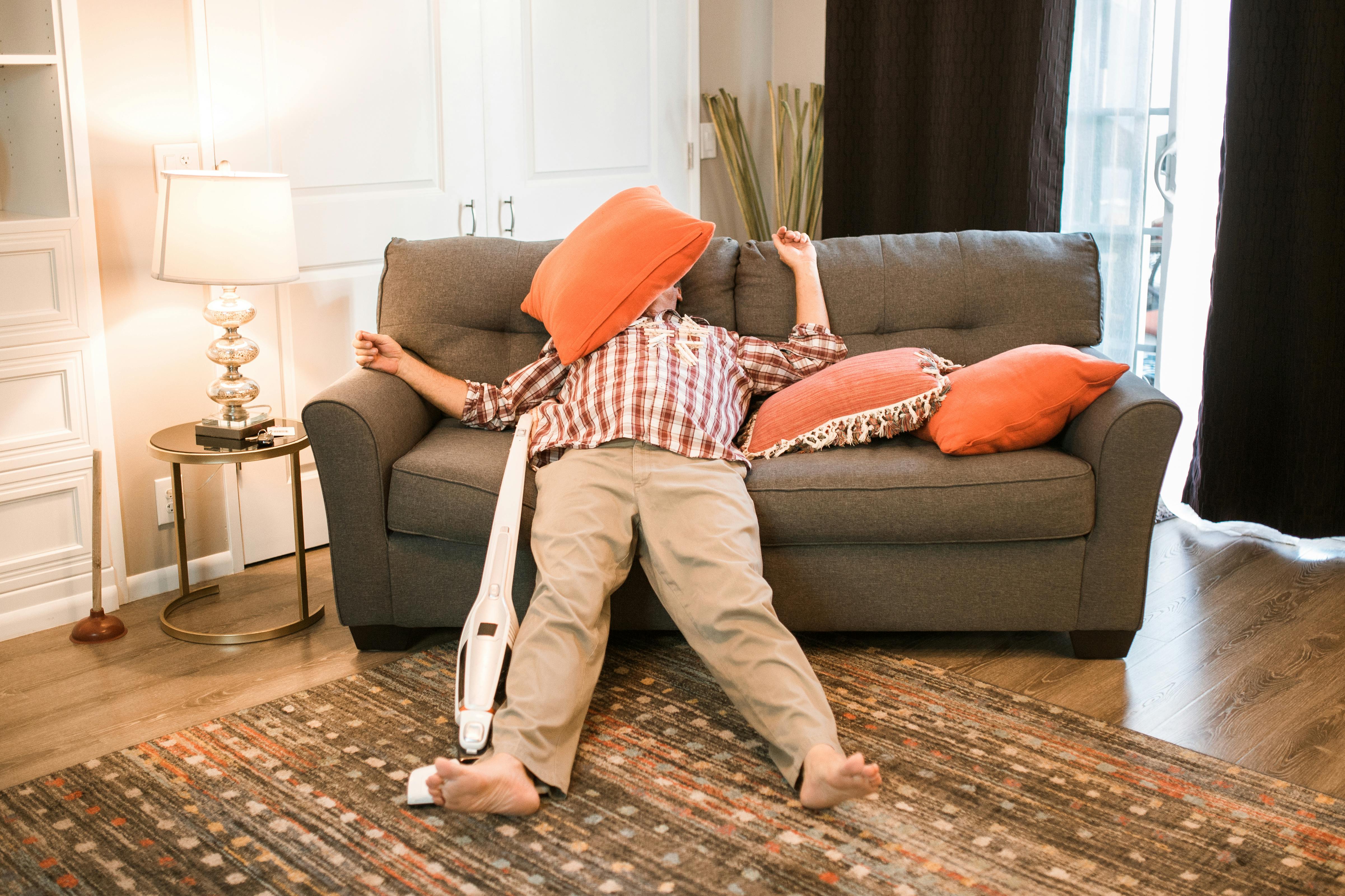 Hombre cansado tumbado en un sofá | Fuente: Pexels