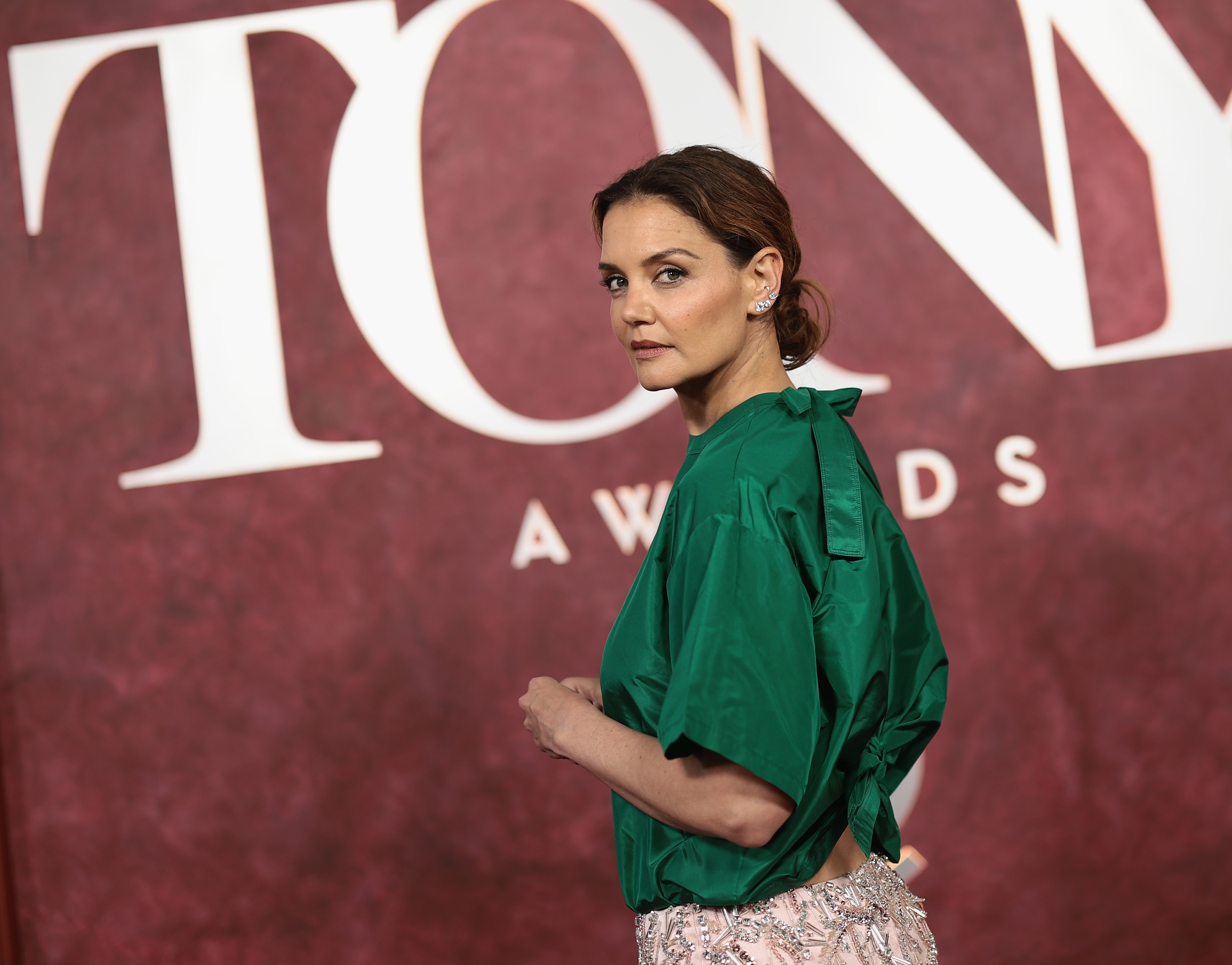 La actriz acapara todas las miradas con un vibrante top verde esmeralda y una falda de cuentas rosa pálido durante su llegada a la 78.ª edición de los Premios Tony, optando por un look minimalista pero llamativo sobre el fondo rojo intenso del evento.