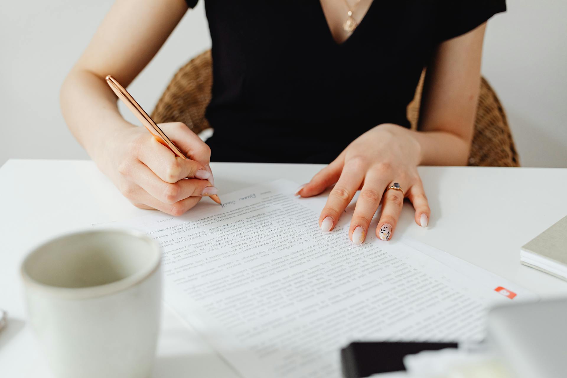 Una mujer firmando un documento | Fuente: Pexels