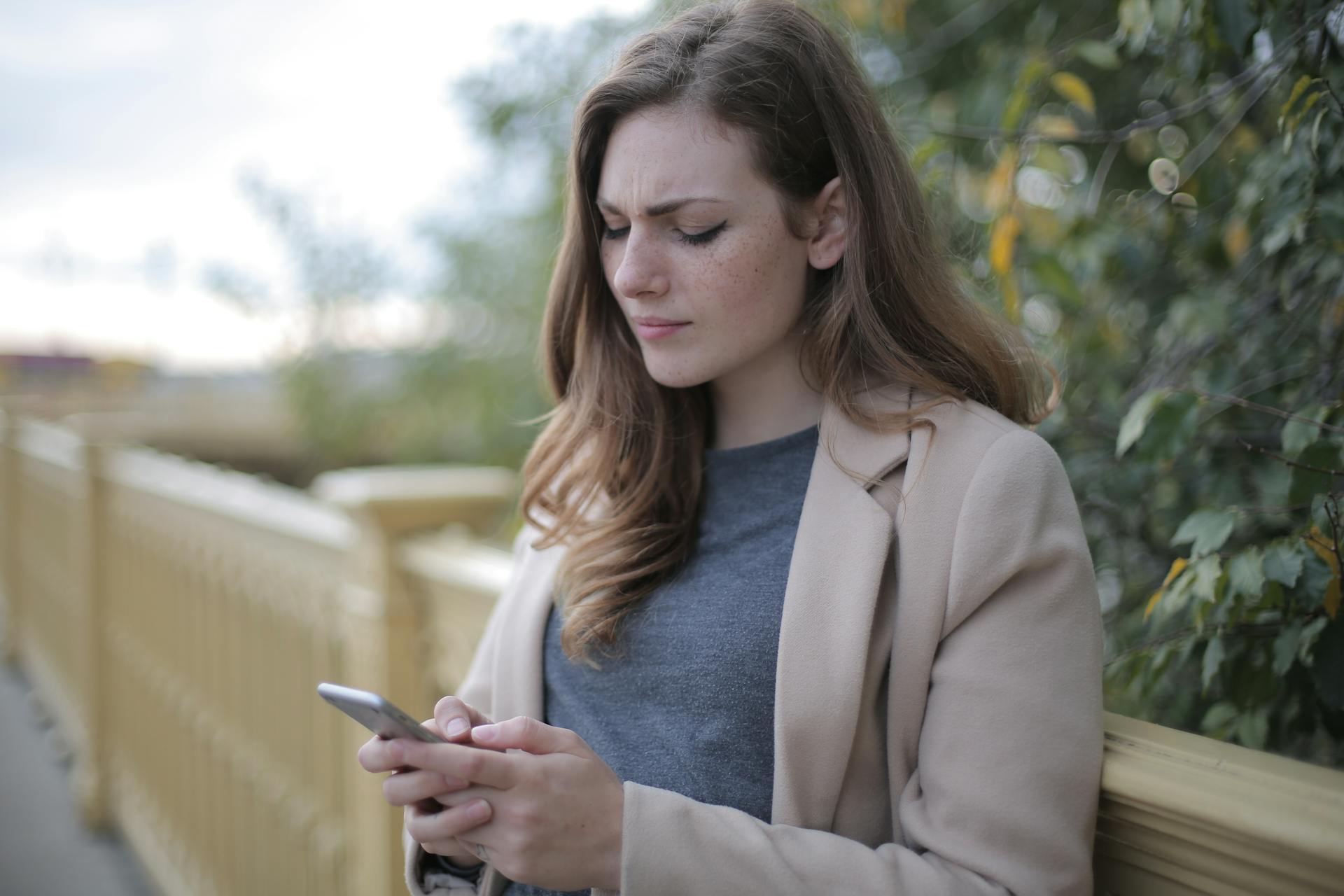 Una mujer frunce el ceño mientras mira su teléfono | Fuente: Pexels