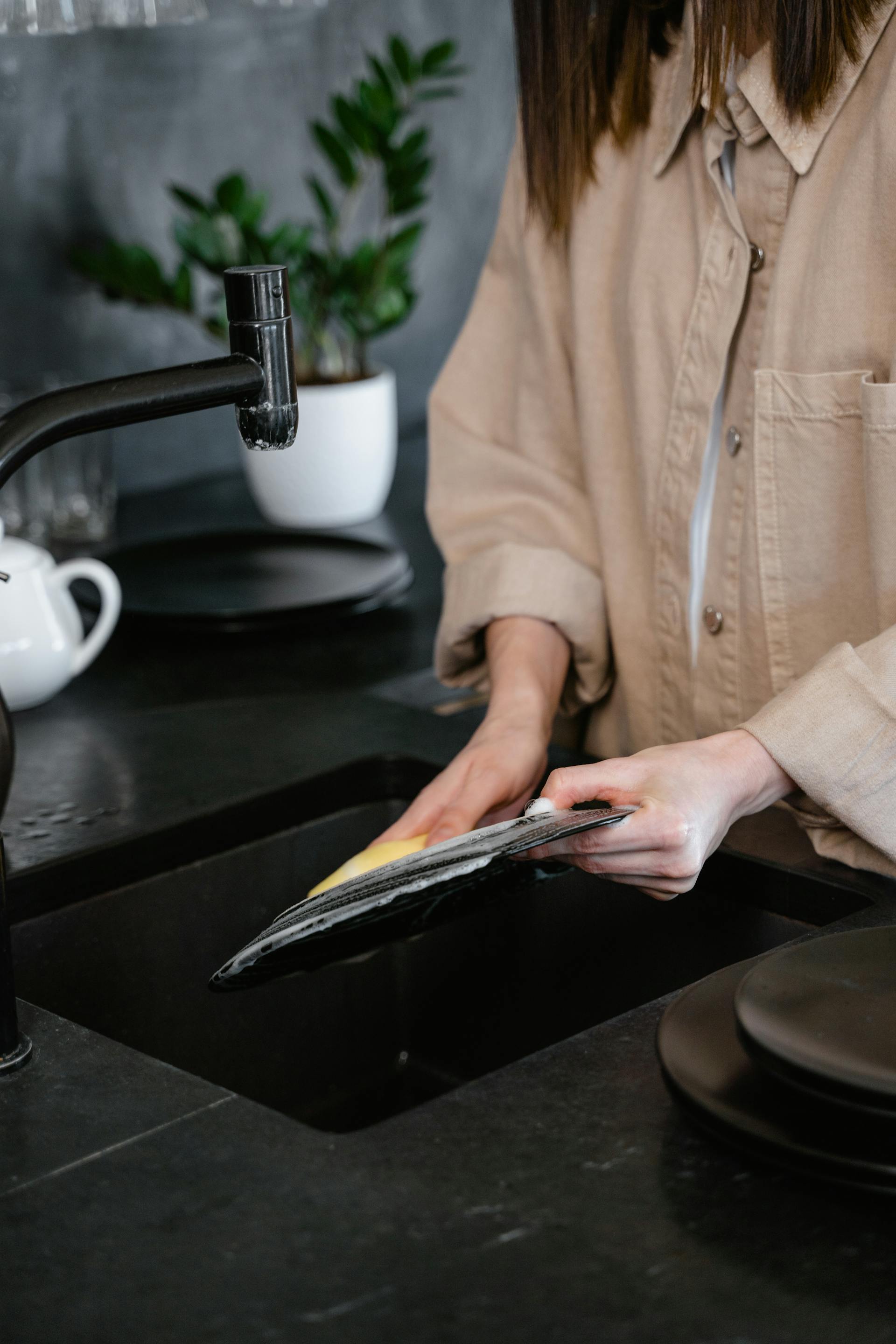 Una mujer lavando un plato de comida | Fuente: Pexels