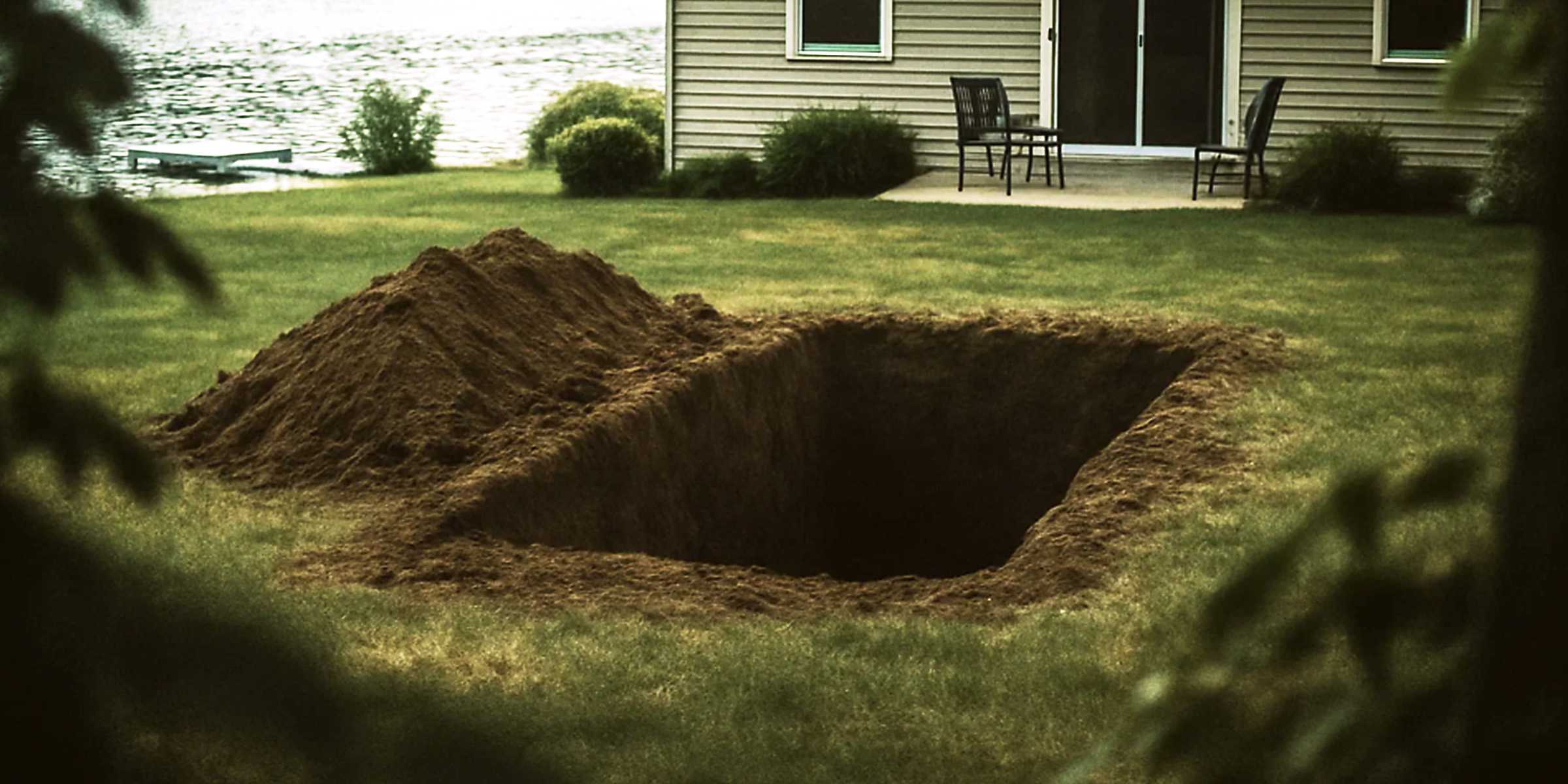 Una fosa recién excavada, del tamaño de una tumba, detrás de una casa del lago | Fuente: Barabola