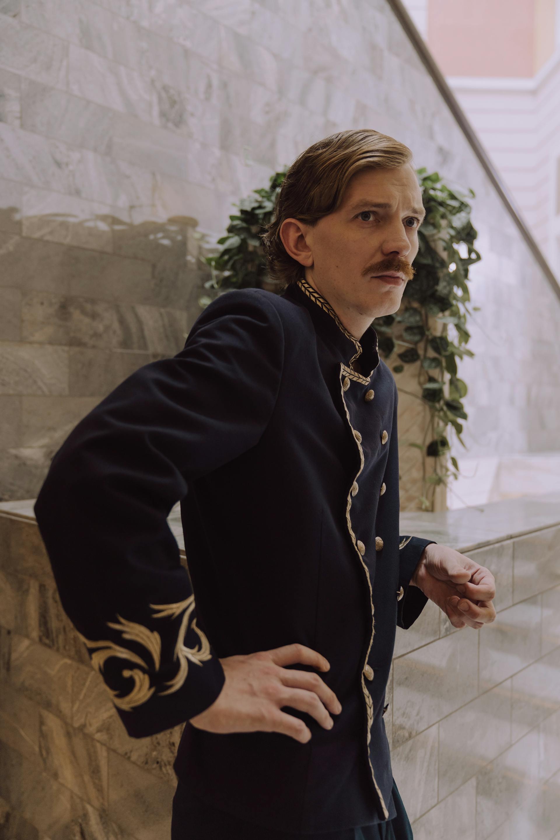 Un hombre con uniforme de conserje de hotel y expresión seria | Fuente: Pexels