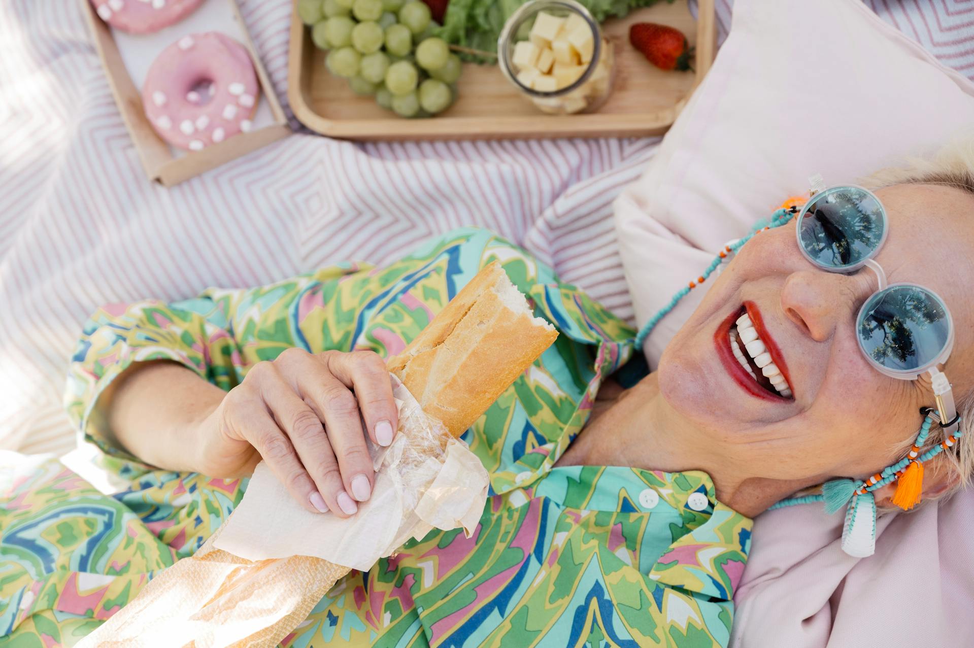Una mujer mayor tumbada mientras sostiene una hogaza de pan | Fuente: Pexels