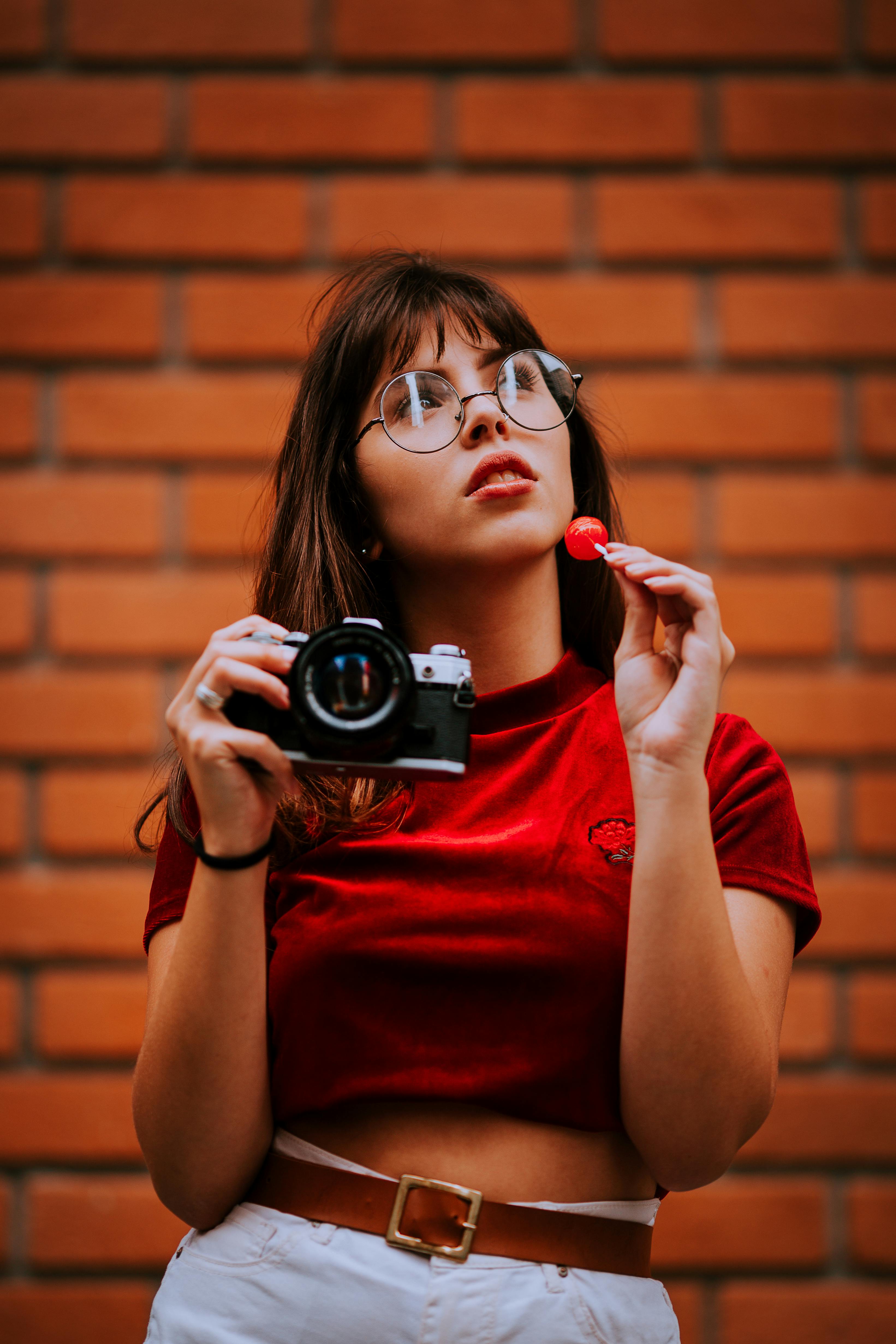 Una joven con una cámara en la mano | Fuente: Pexels