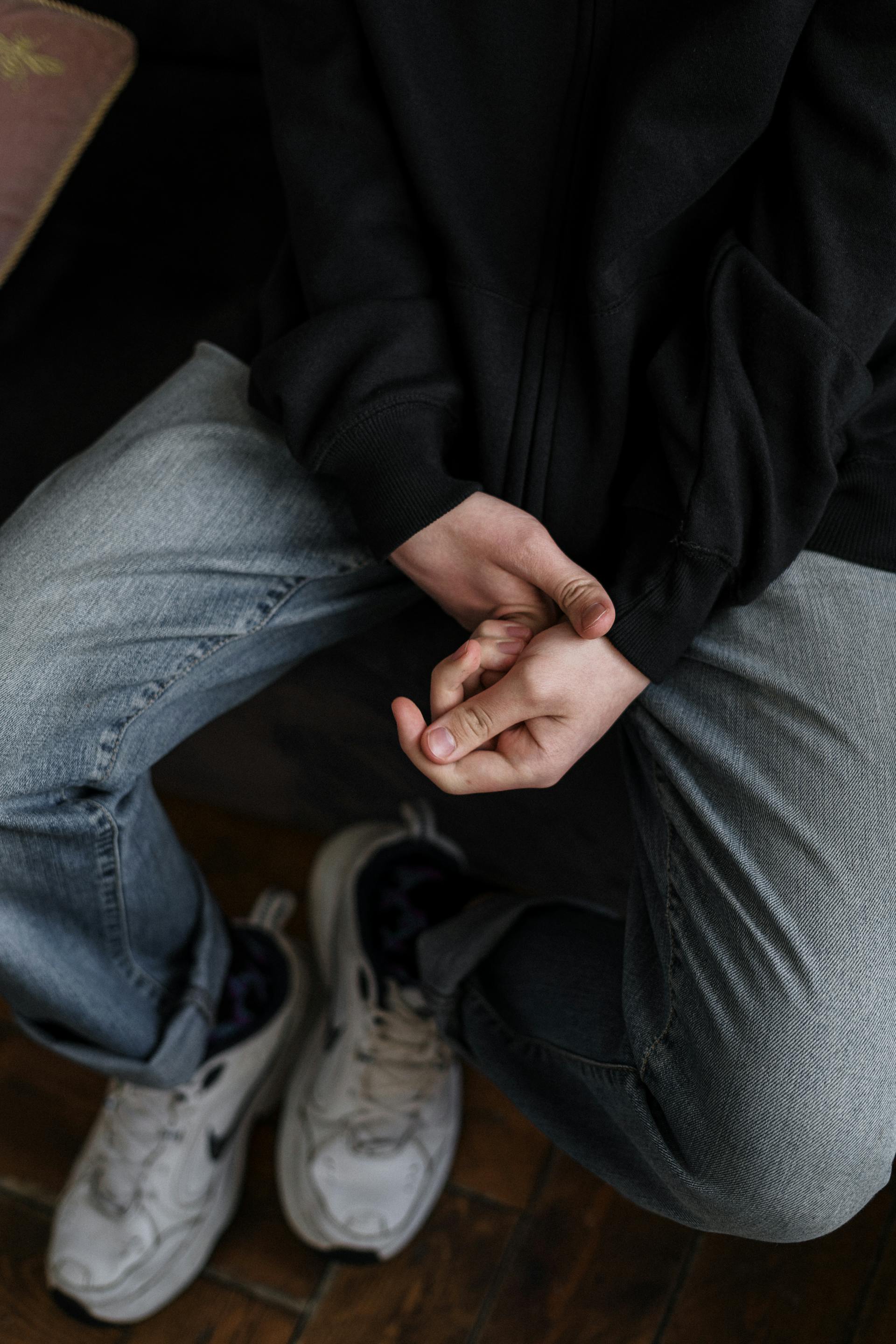 Primer plano de una persona con chaqueta negra y vaqueros | Fuente: Pexels