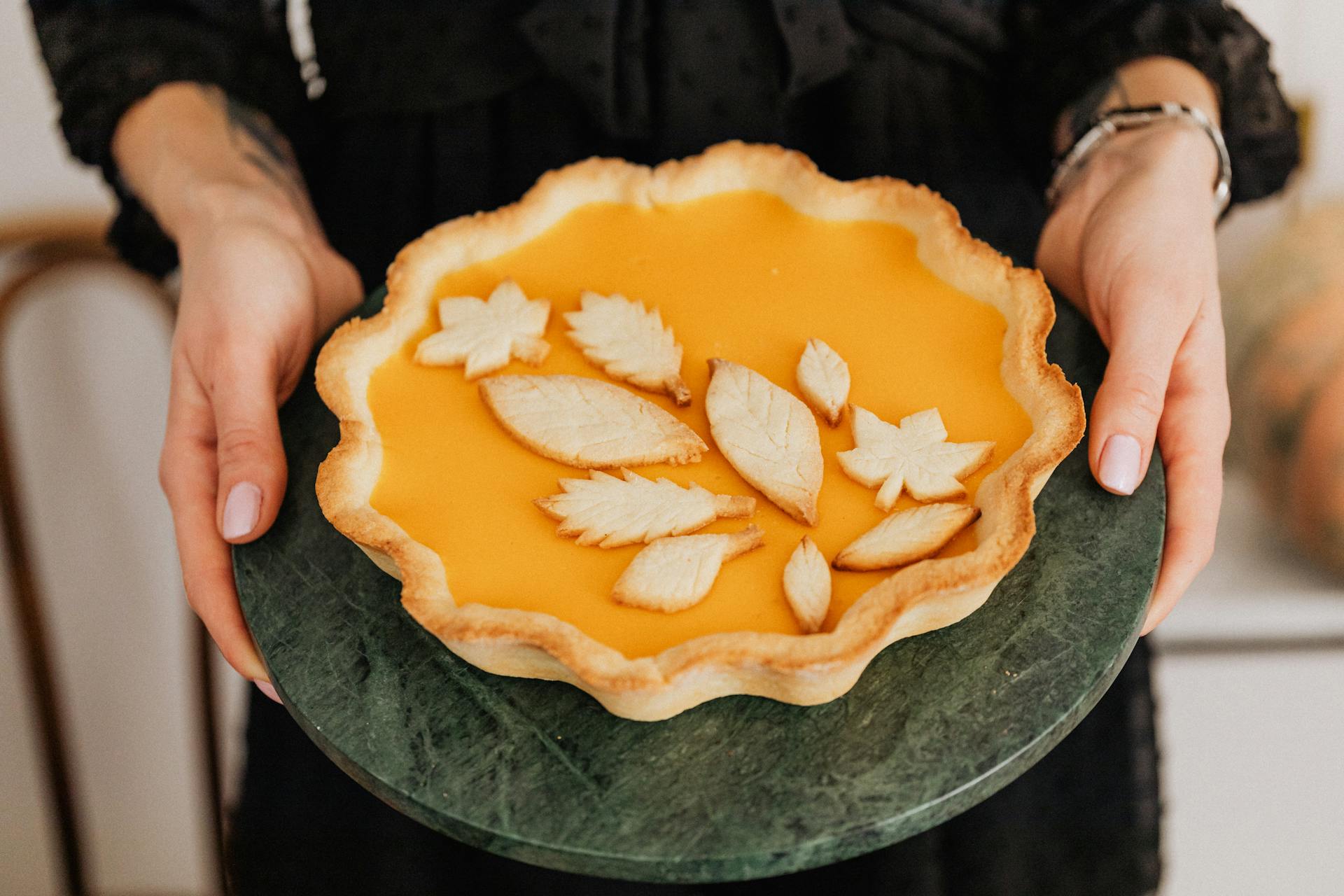 Una mujer sujetando una tarta de calabaza | Fuente: Pexels