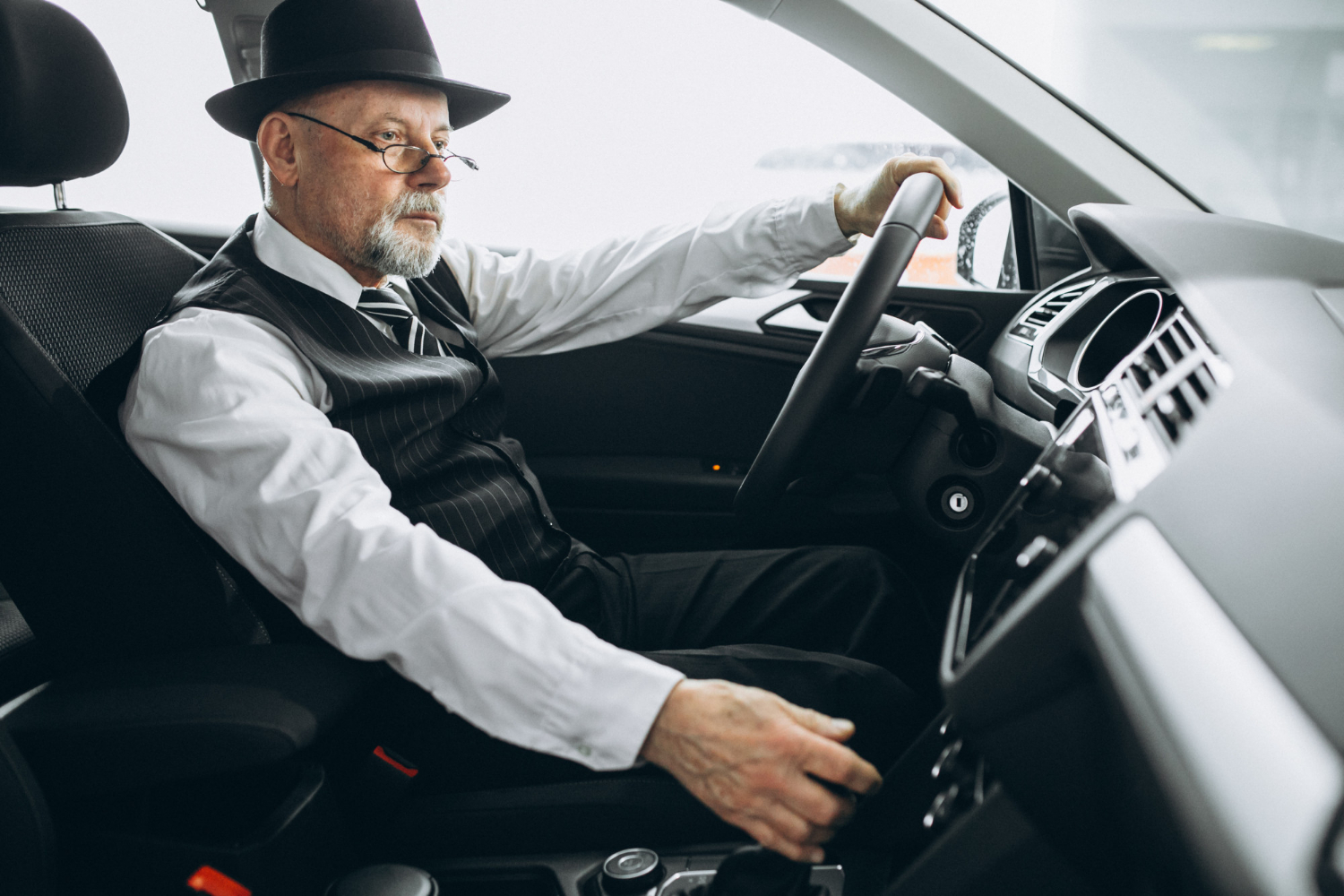 Un anciano adinerado conduciendo su Automóvil | Fuente: Freepik