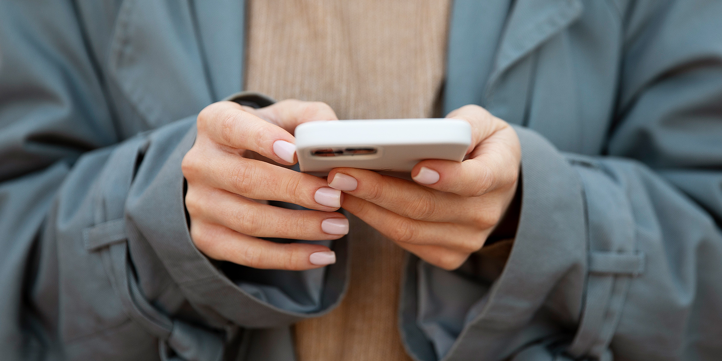 Una mujer sujetando su teléfono | Fuente: Freepik