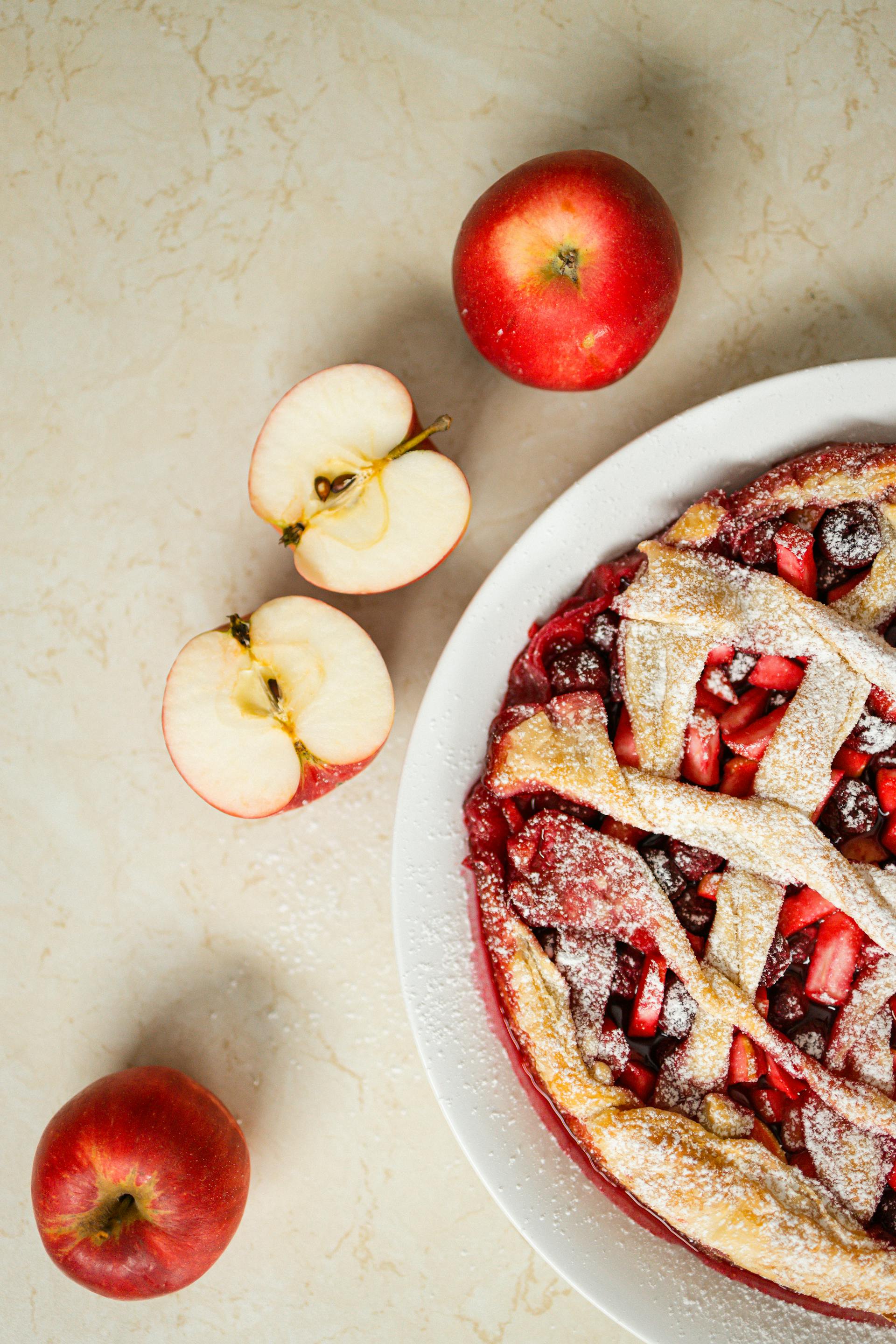 Manzanas tumbadas junto a una tarta de manzana | Fuente: Pexels