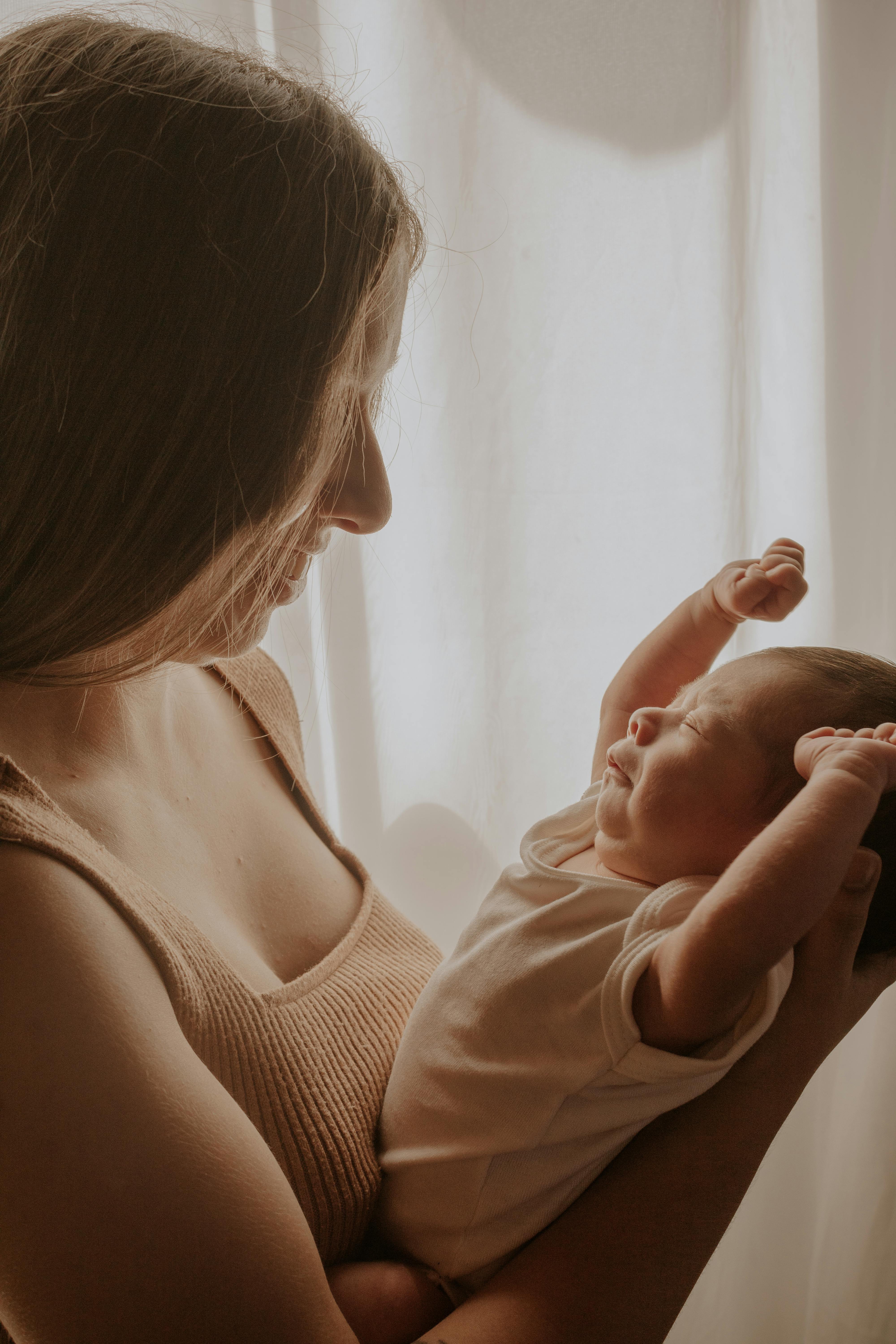 Una mujer con un bebé en brazos | Fuente: Pexels