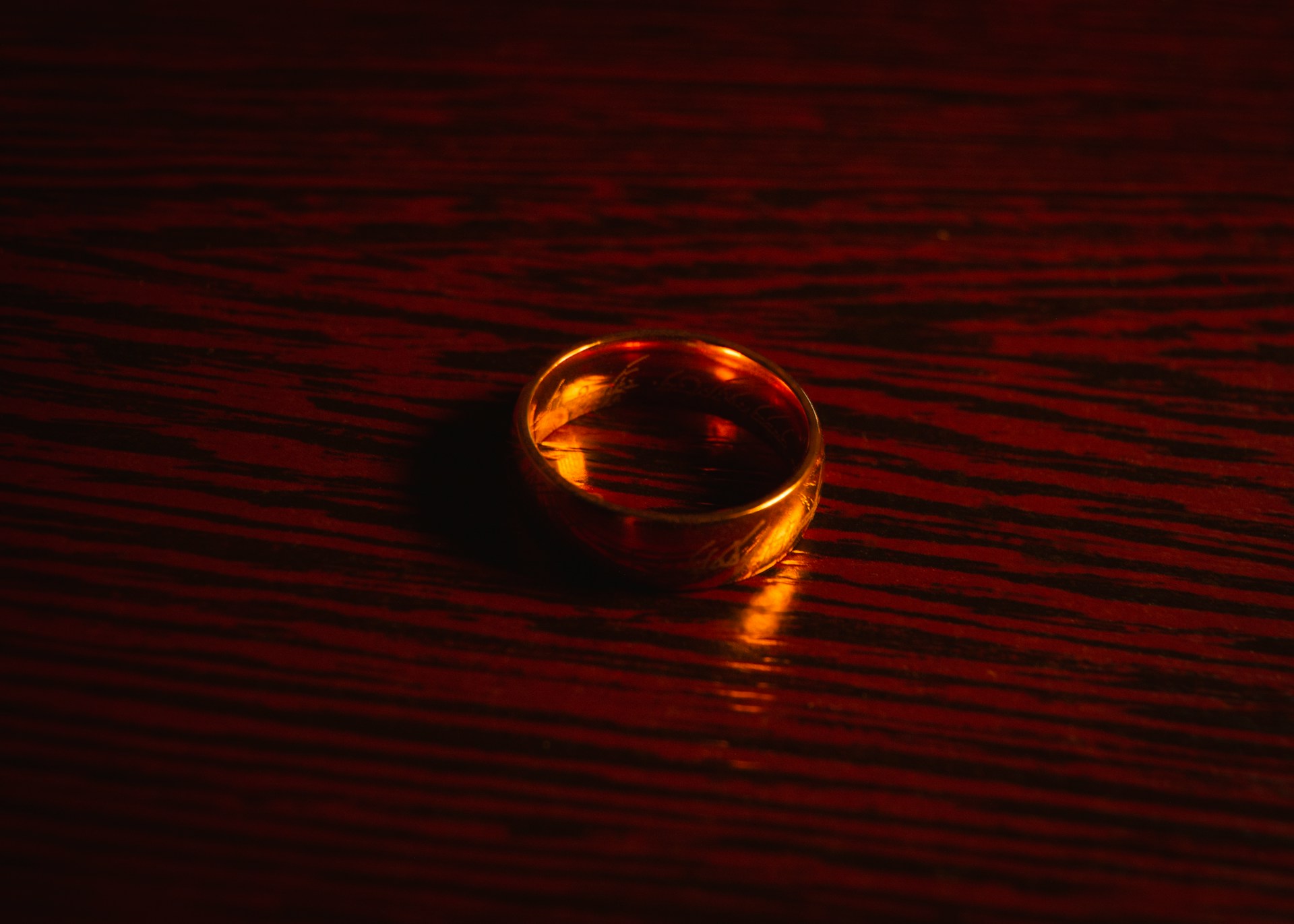 Primer plano de un anillo de oro sobre una superficie de madera marrón | Fuente: Unsplash