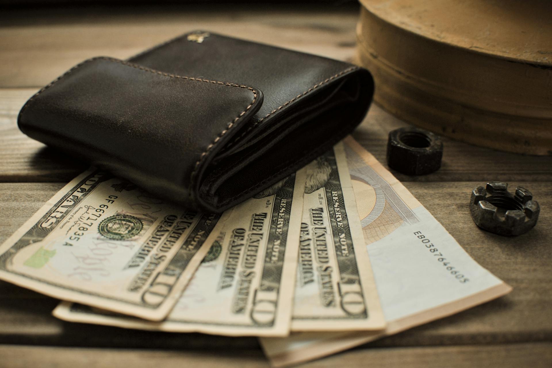 Una cartera sobre billetes de dólar | Fuente: Pexels