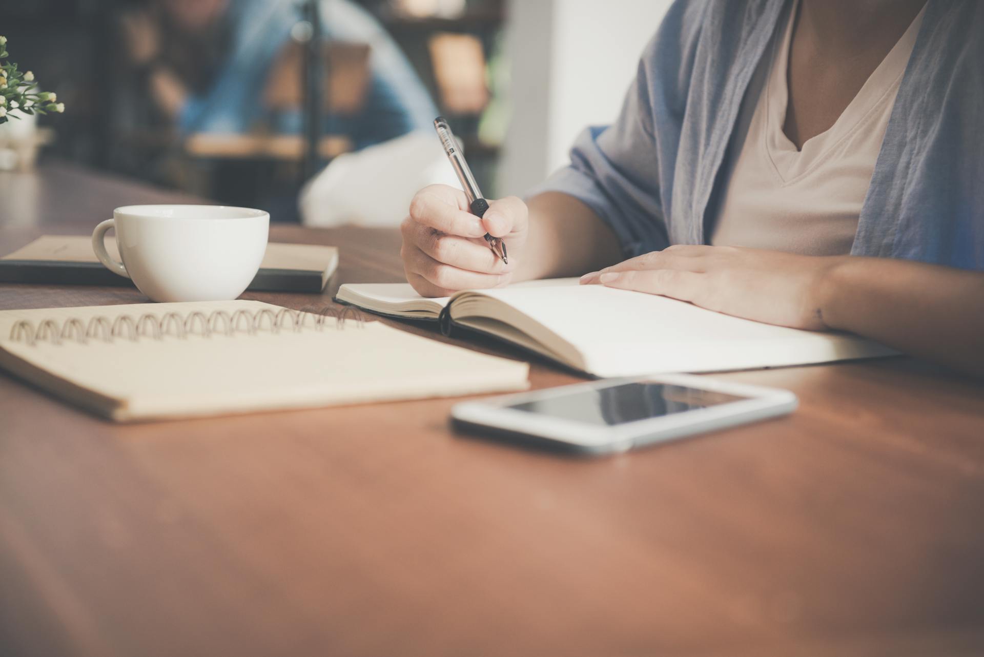 Una mujer escribiendo en un cuaderno | Sourrce: Pexels
