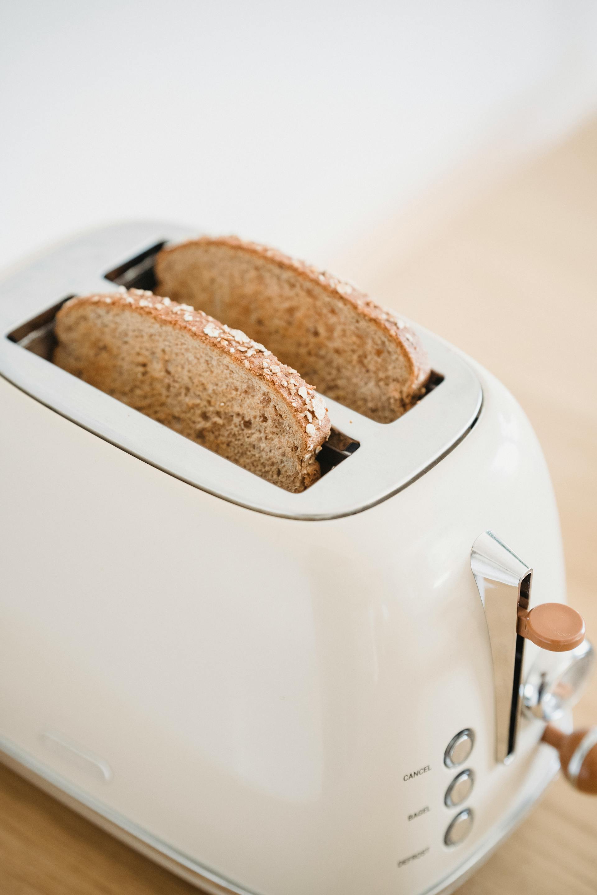 Primer plano de rebanadas de pan en una tostadora | Fuente: Pexels