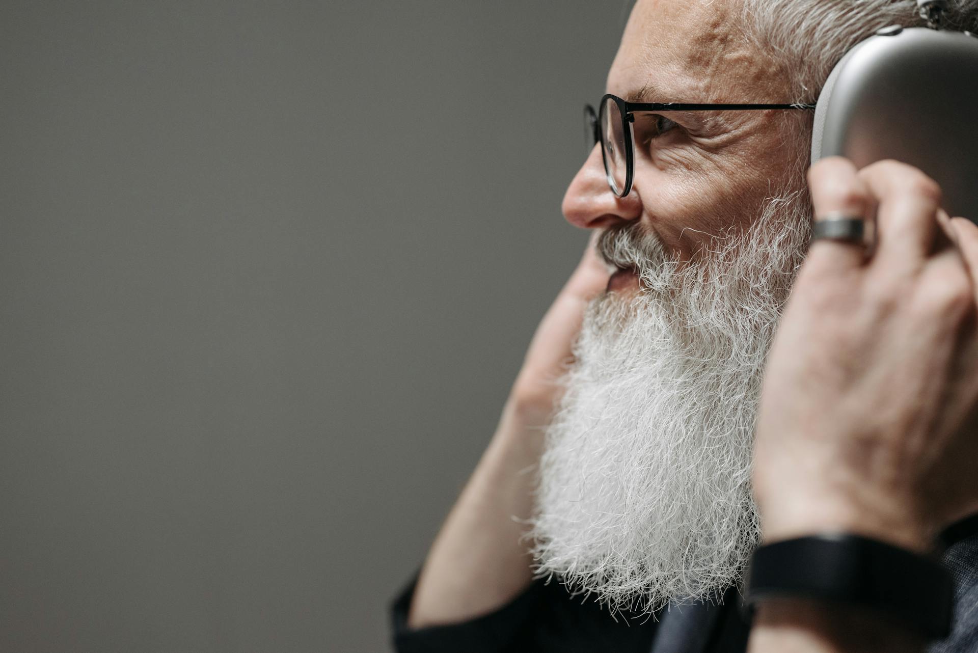Un hombre barbudo sonriente con auriculares | Fuente: Pexels