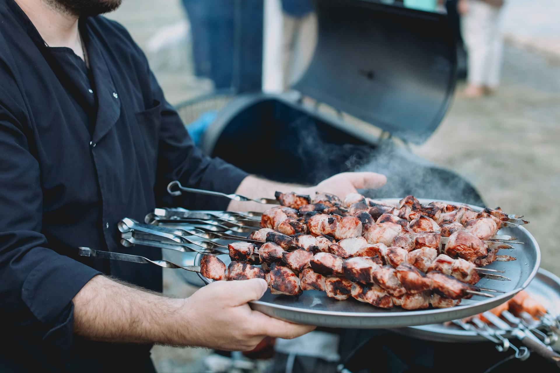 Un hombre sujetando una bandeja de carne | Fuente: Pexels