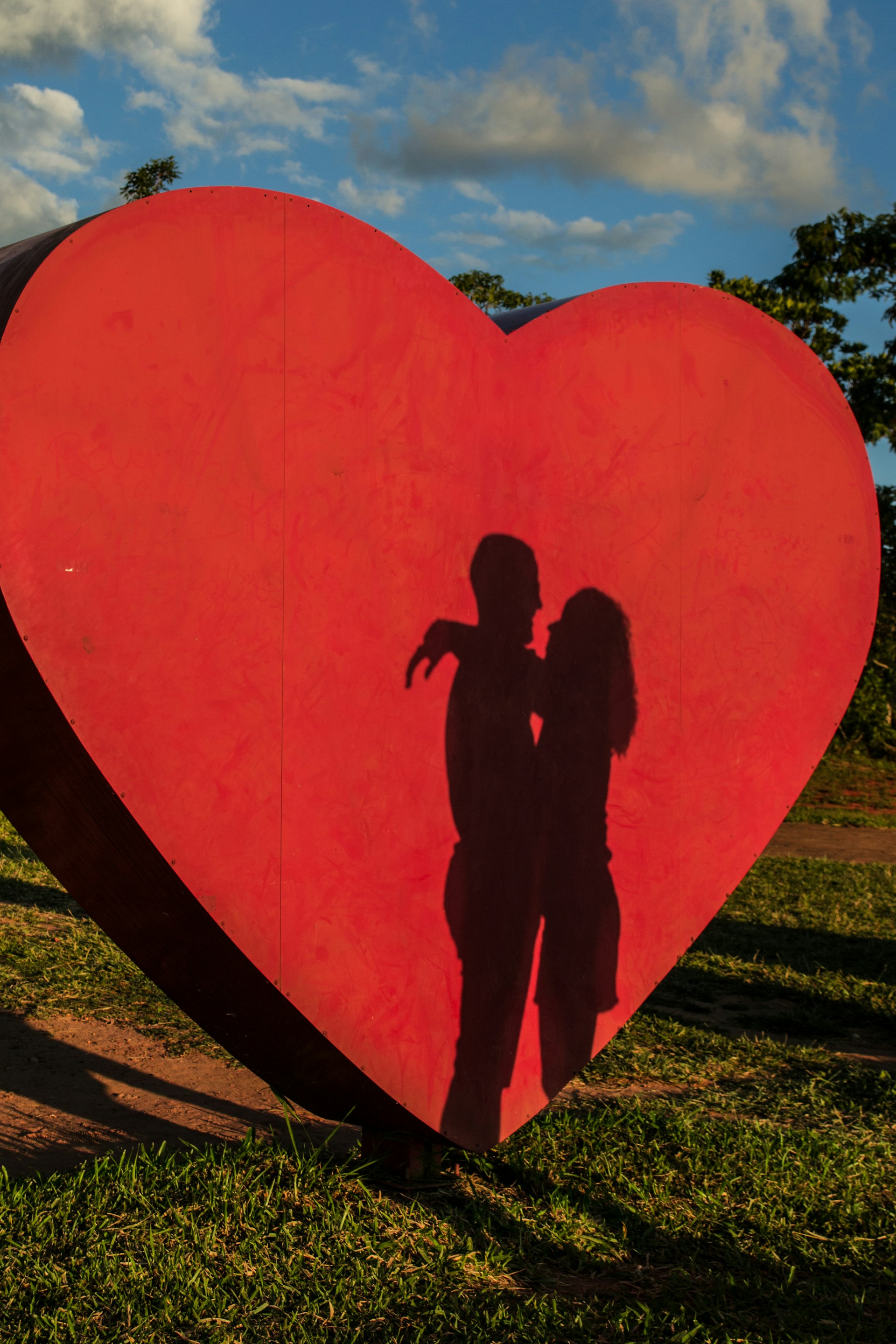 Sombra de una pareja abrazándose con el telón de fondo de un recorte gigante en forma de corazón | Fuente: Unsplash