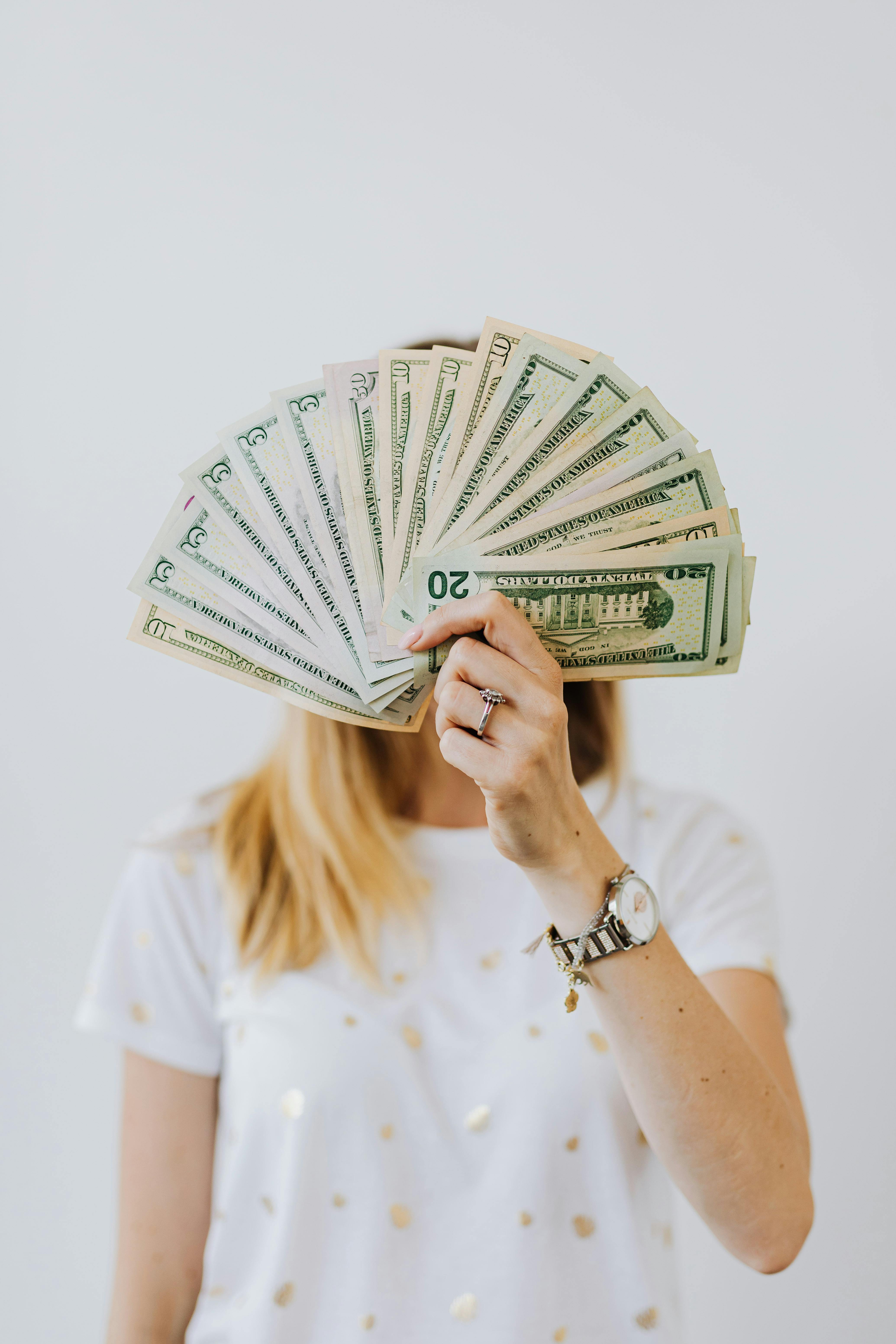 Una mujer con dinero en la mano | Fuente: Pexels