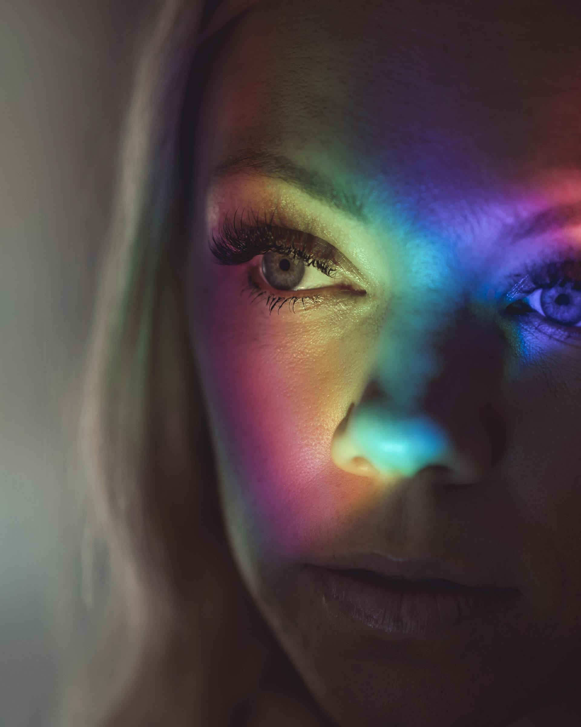 El rostro de una bella mujer iluminado por luces de colores | Fuente: Pexels