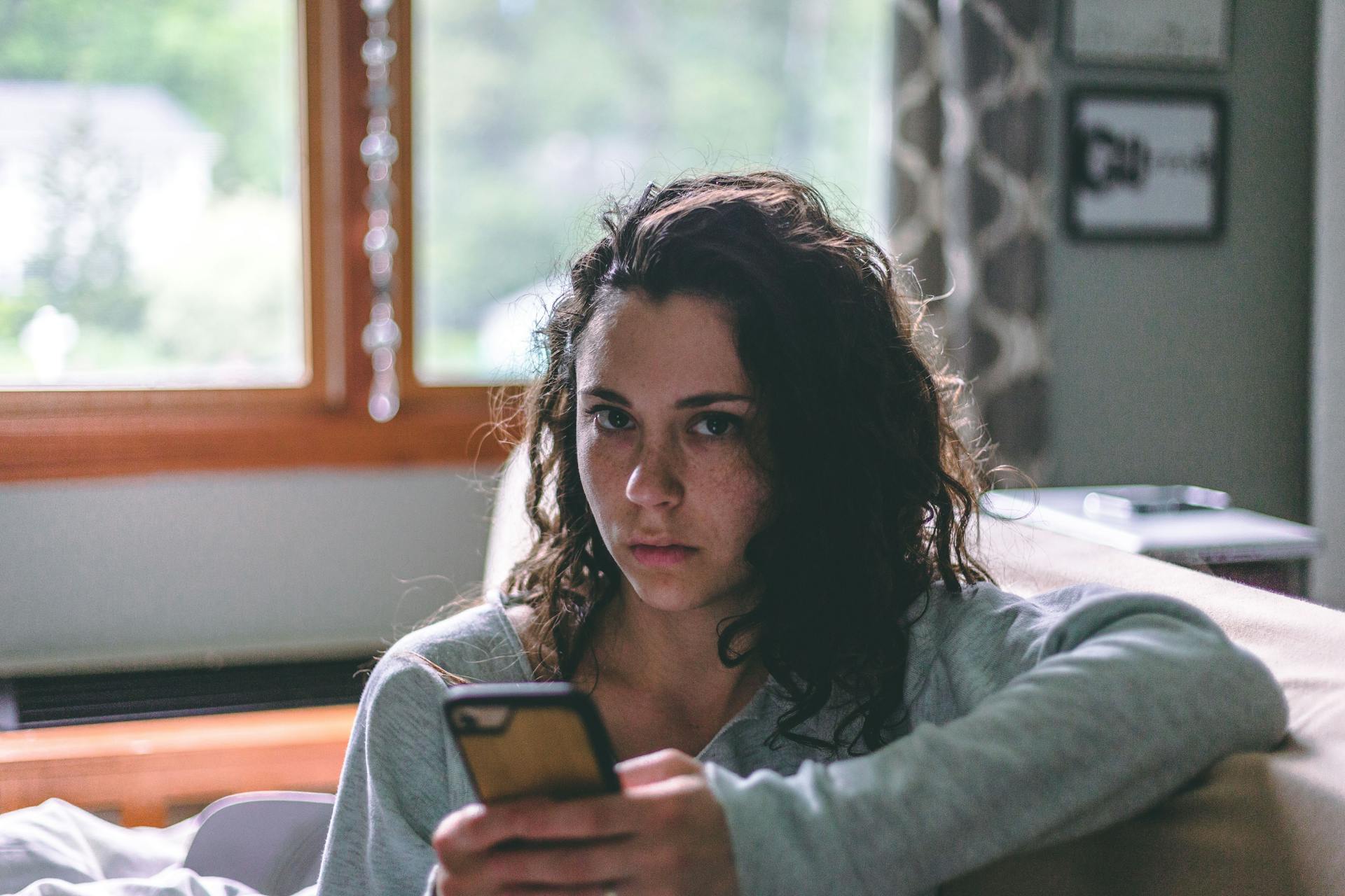 Una mujer sujetando un teléfono móvil | Fuente: Pexels