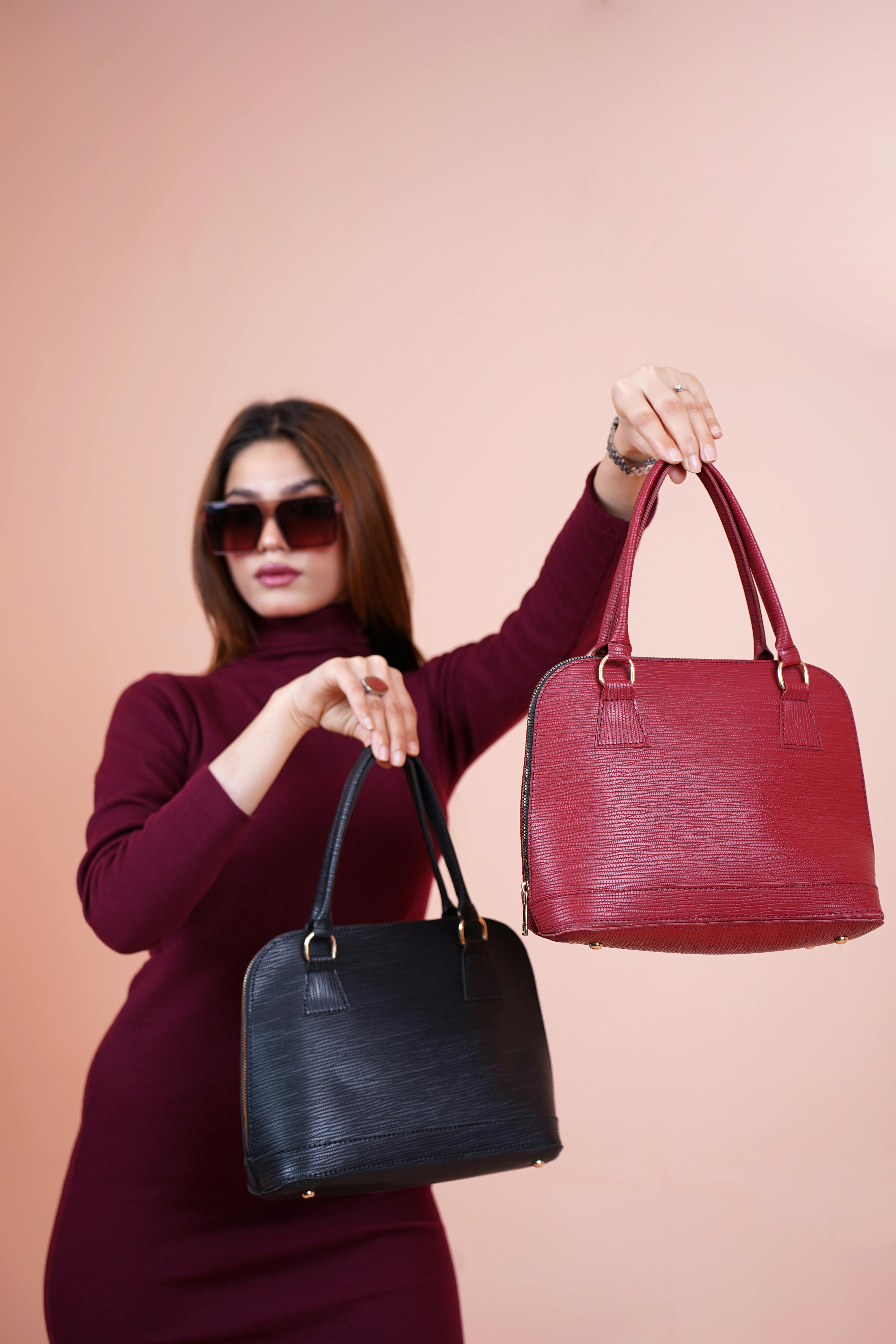 Una mujer mostrando sus bolsos de diseñador | Fuente: Pexels