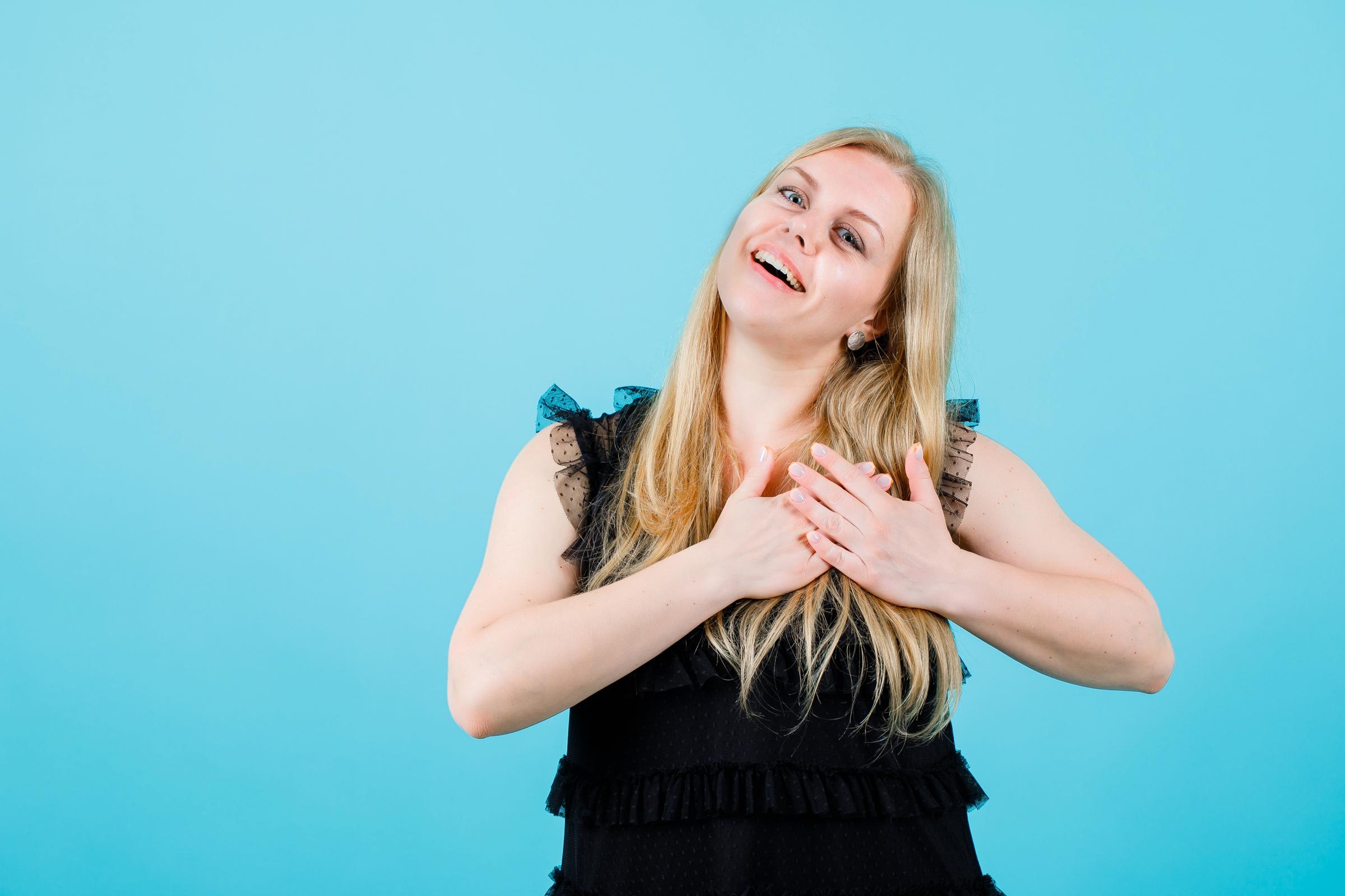 Una mujer haciendo un voto con las manos sobre el corazón | Fuente: Freepik