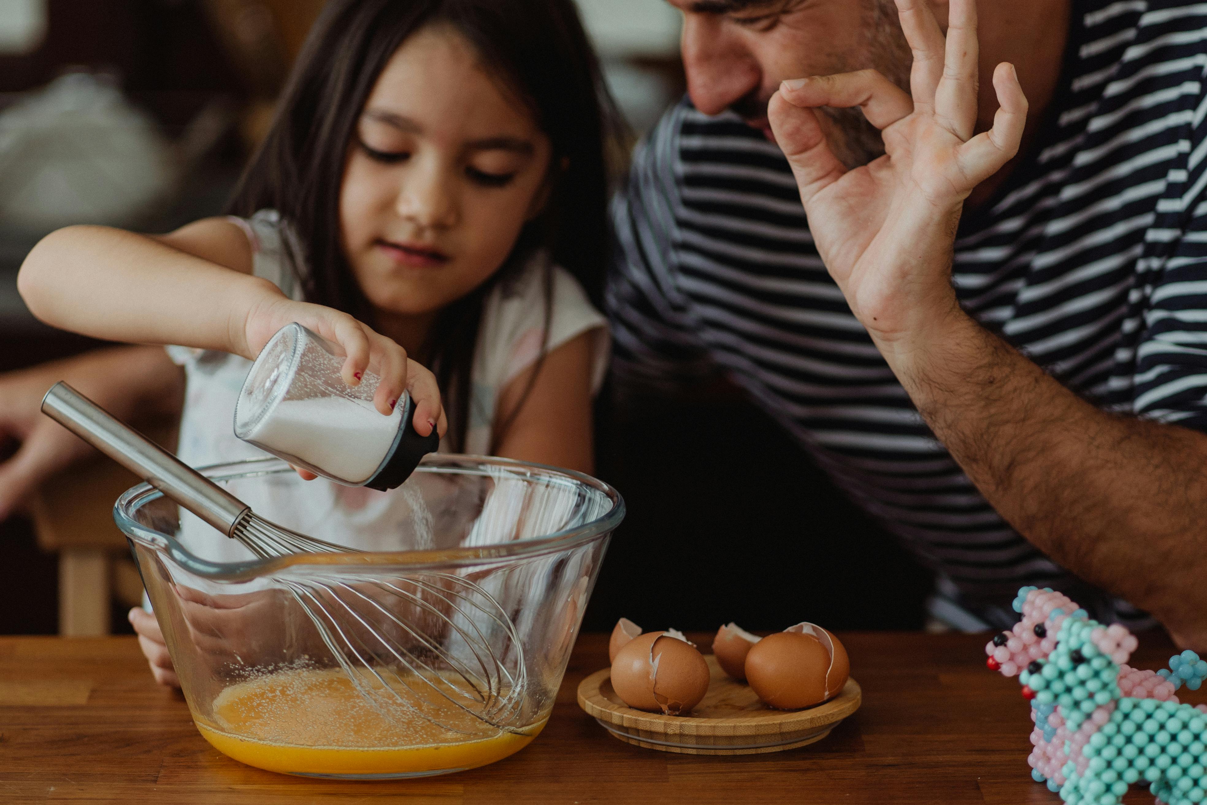 Un padre y su hija cocinando juntos | Fuente: Pexels