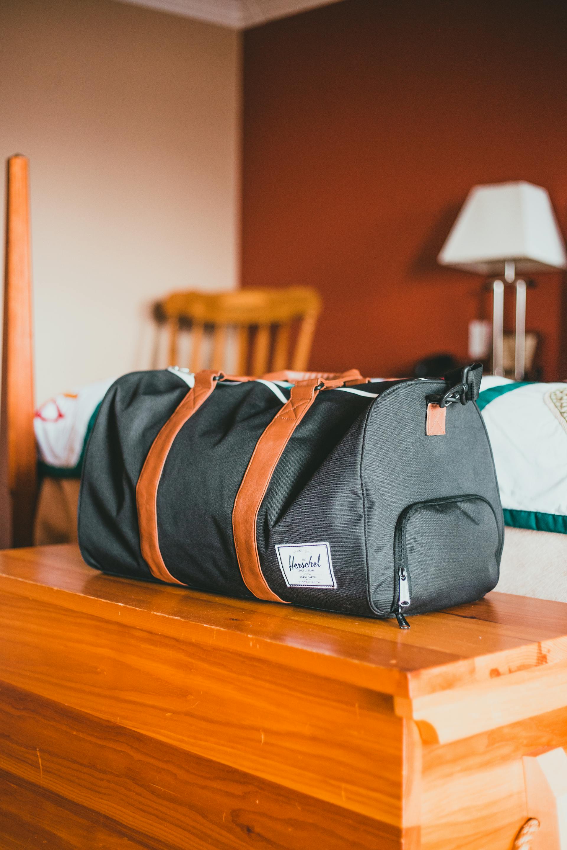 Una bolsa de viaje sobre una mesa de madera | Fuente: Pexels