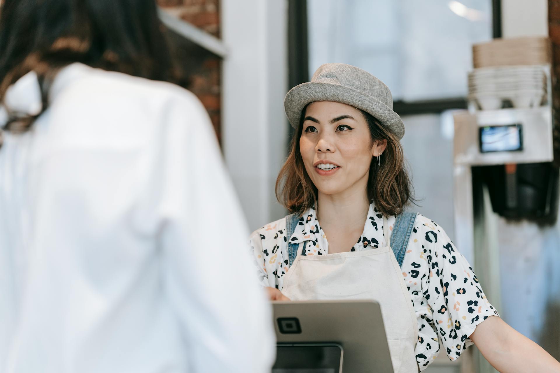Una cajera hablando con un cliente | Fuente: Pexels