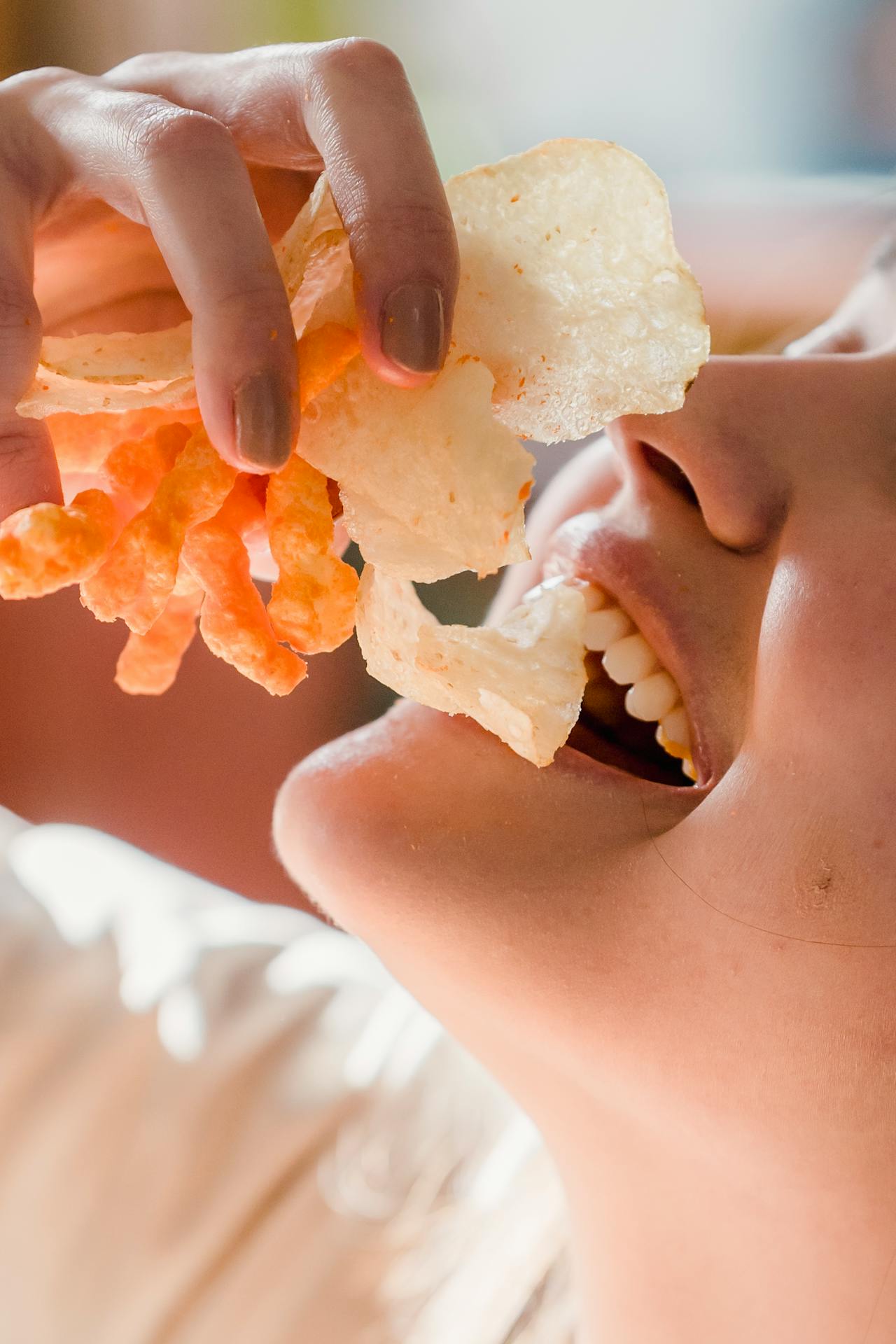 Una mujer comiendo aperitivos crujientes | Fuente: Pexels