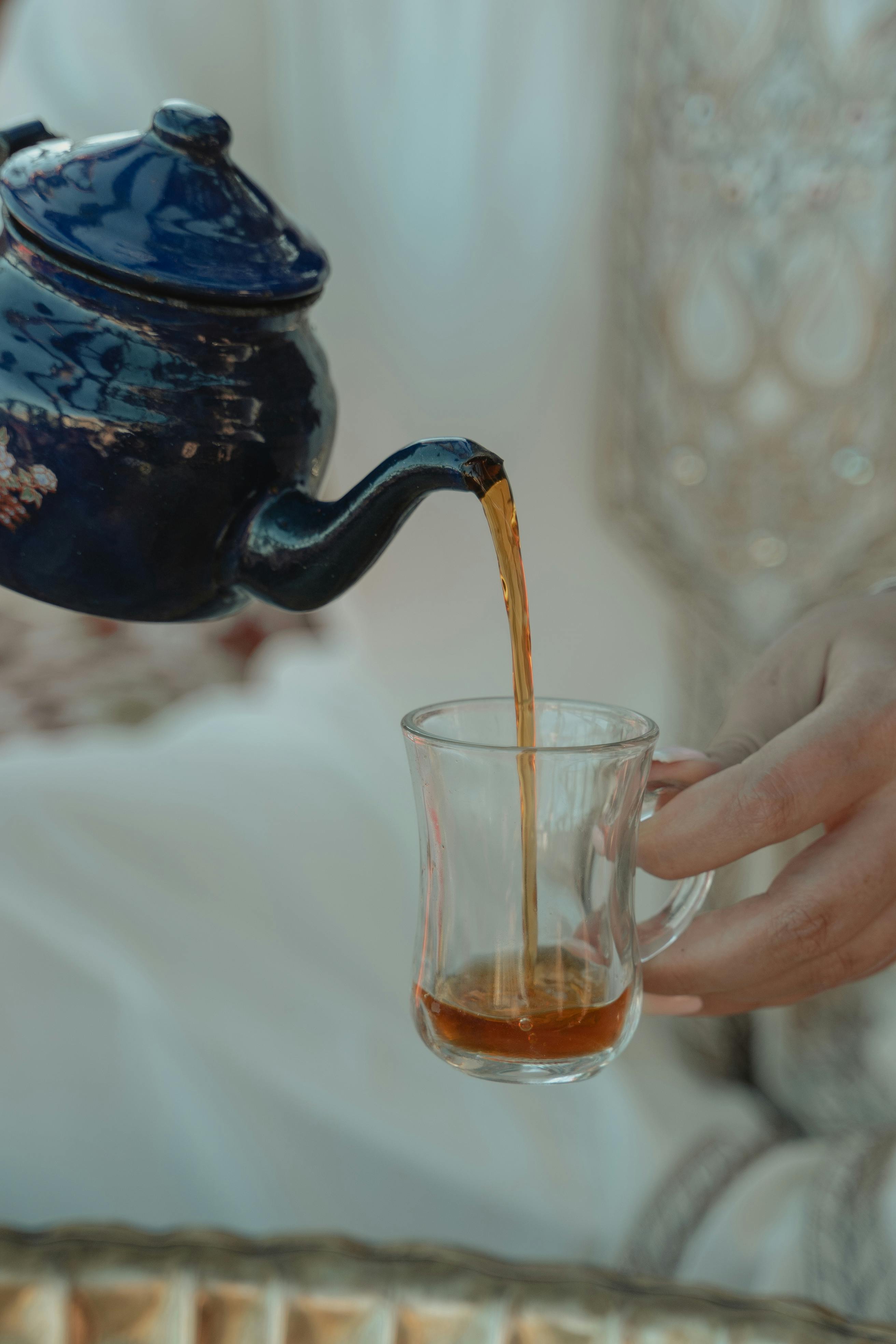La mano de una mujer sirviendo una taza de té | Fuente: Pexels