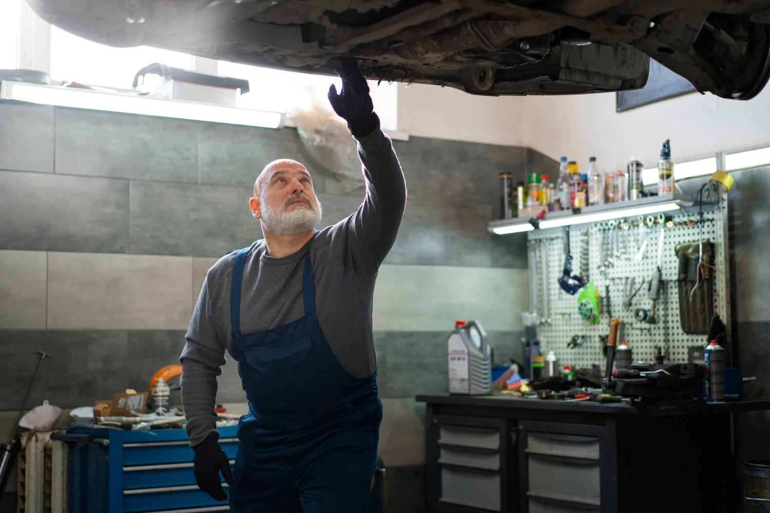 Un mecánico de automóviles inspeccionando un vehículo | Fuente: Freepik