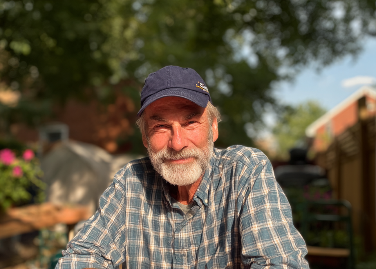 Un hombre mayor sonriente sentado a una mesa | Fuente: Midjourney