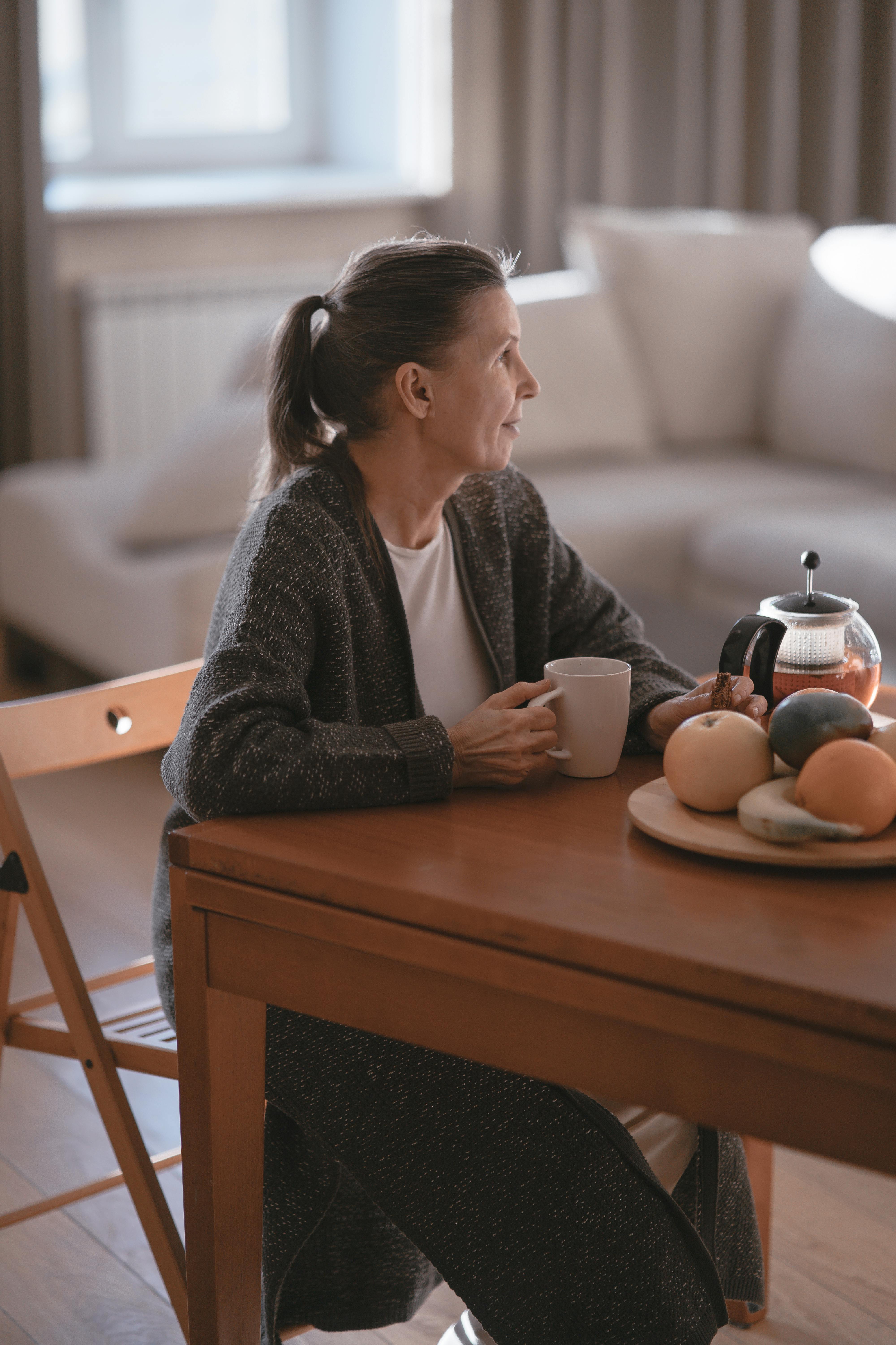 Una mujer sentada a la mesa de la cocina | Fuente: Pexels