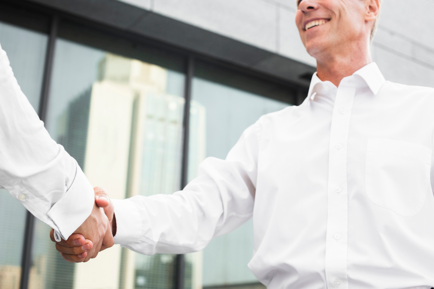 Un elegante hombre de negocios dando la mano a otro hombre | Fuente: Freepik