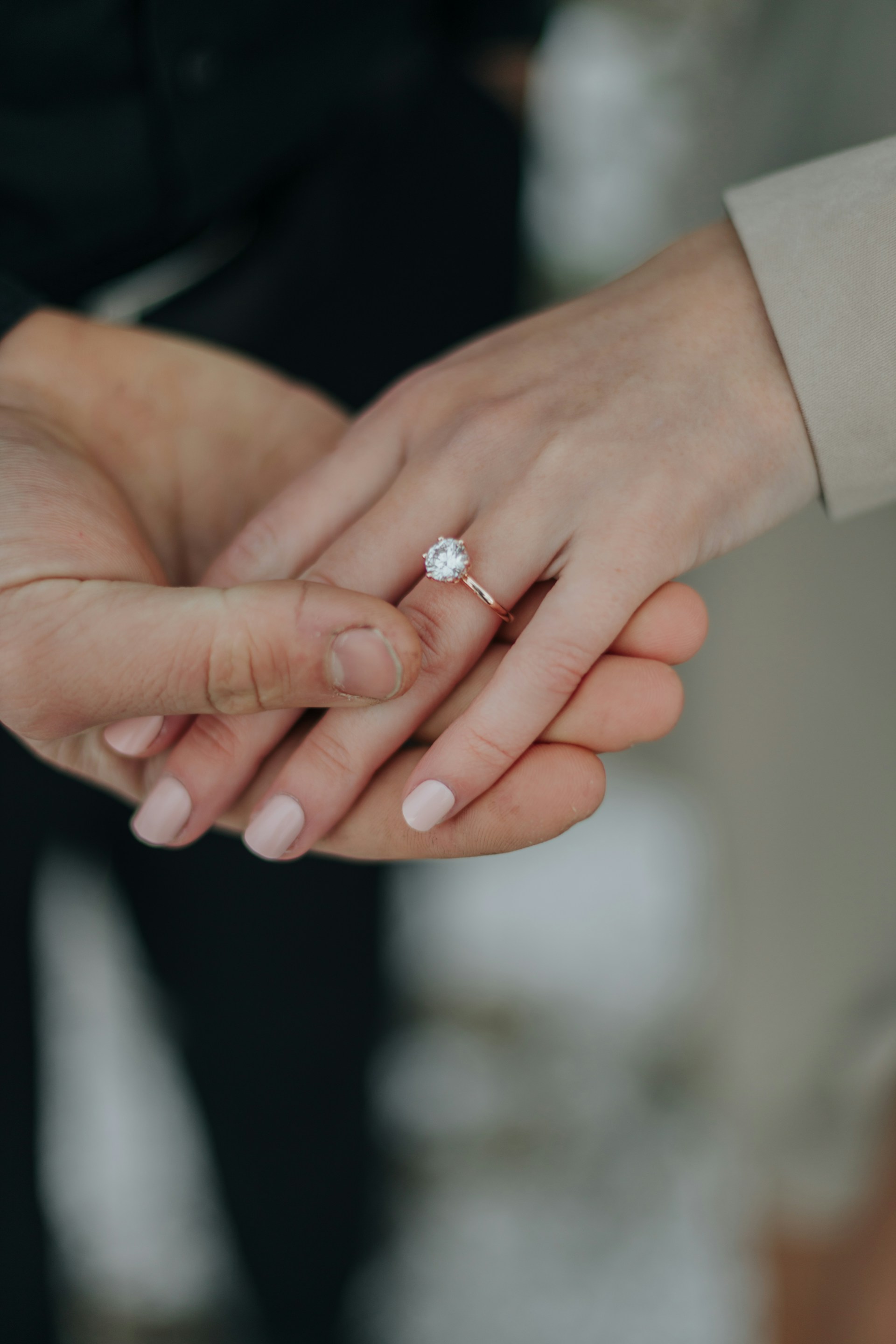 Primer plano de una mujer alardeando de su anillo de diamantes mientras coge la mano de su pareja | Fuente: Unsplash